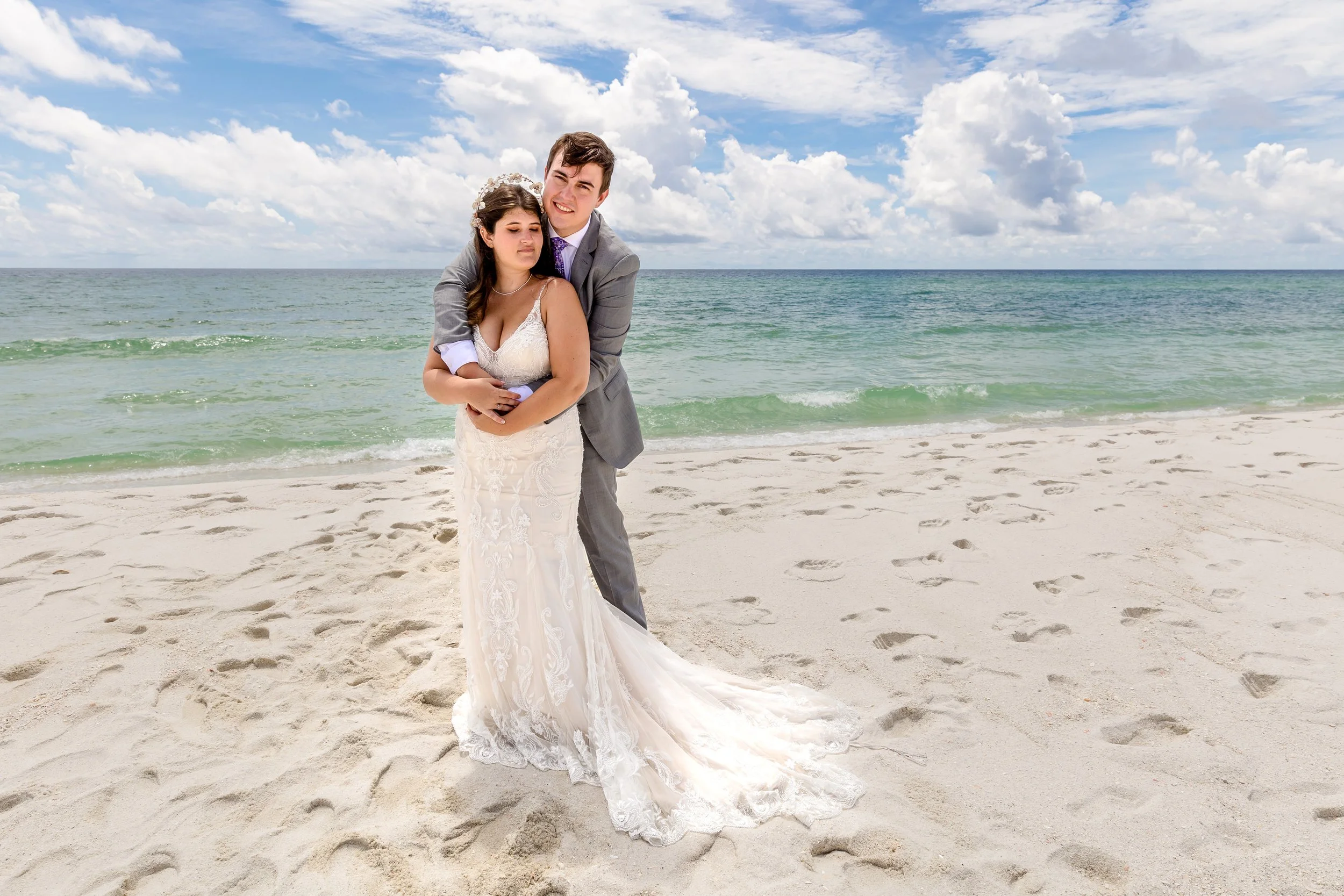 Bride and groom embrace on  Navarre beach taken by Jacksonville beach and St. Augustine Florida Photographer