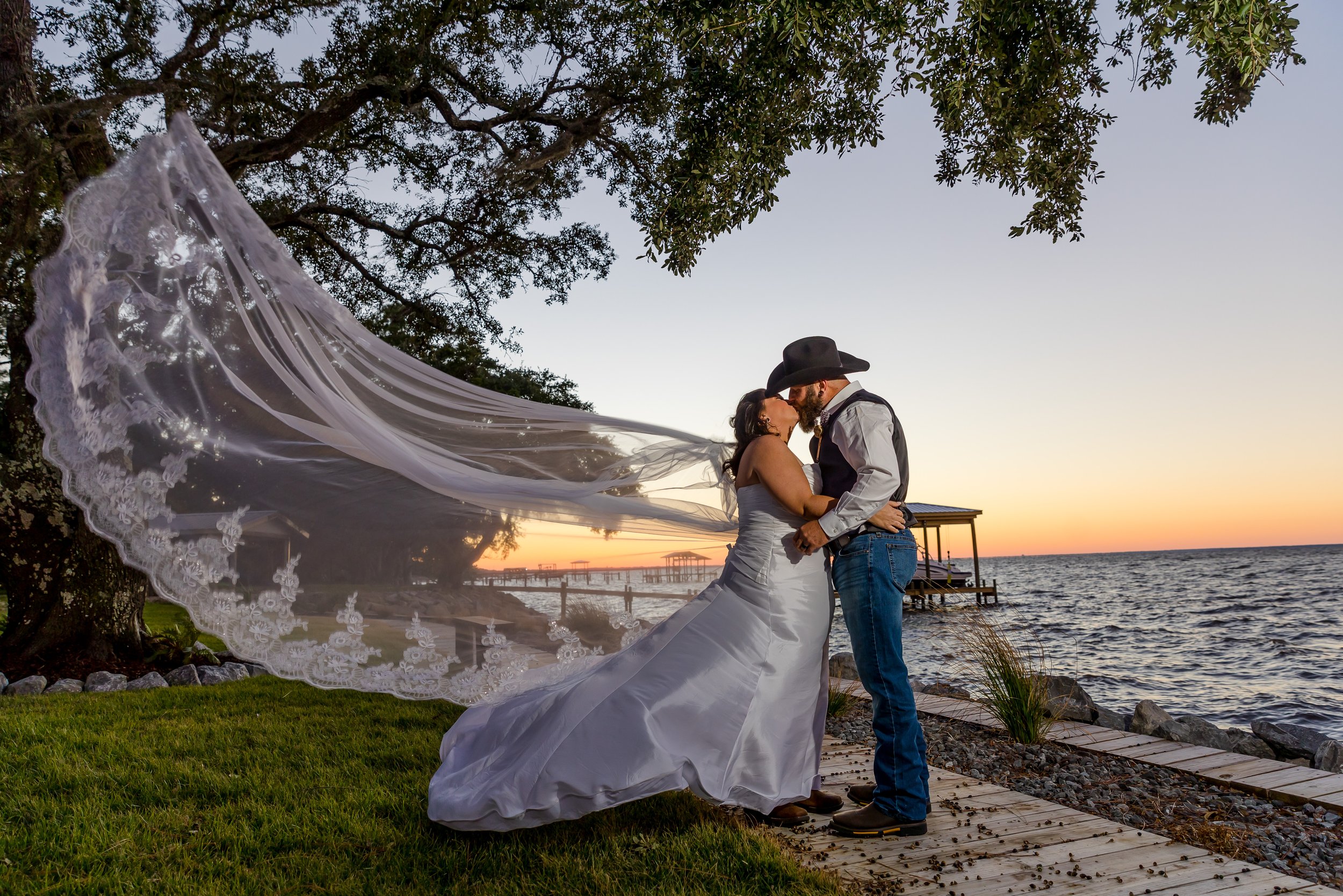 A romantic kissed share by the bride and groom on the lawn at the Bay Front Lodge and Log Cabin in Gulf Breeze picture taken by Jacksonville Beach and St. Augustine Wedding Photographer