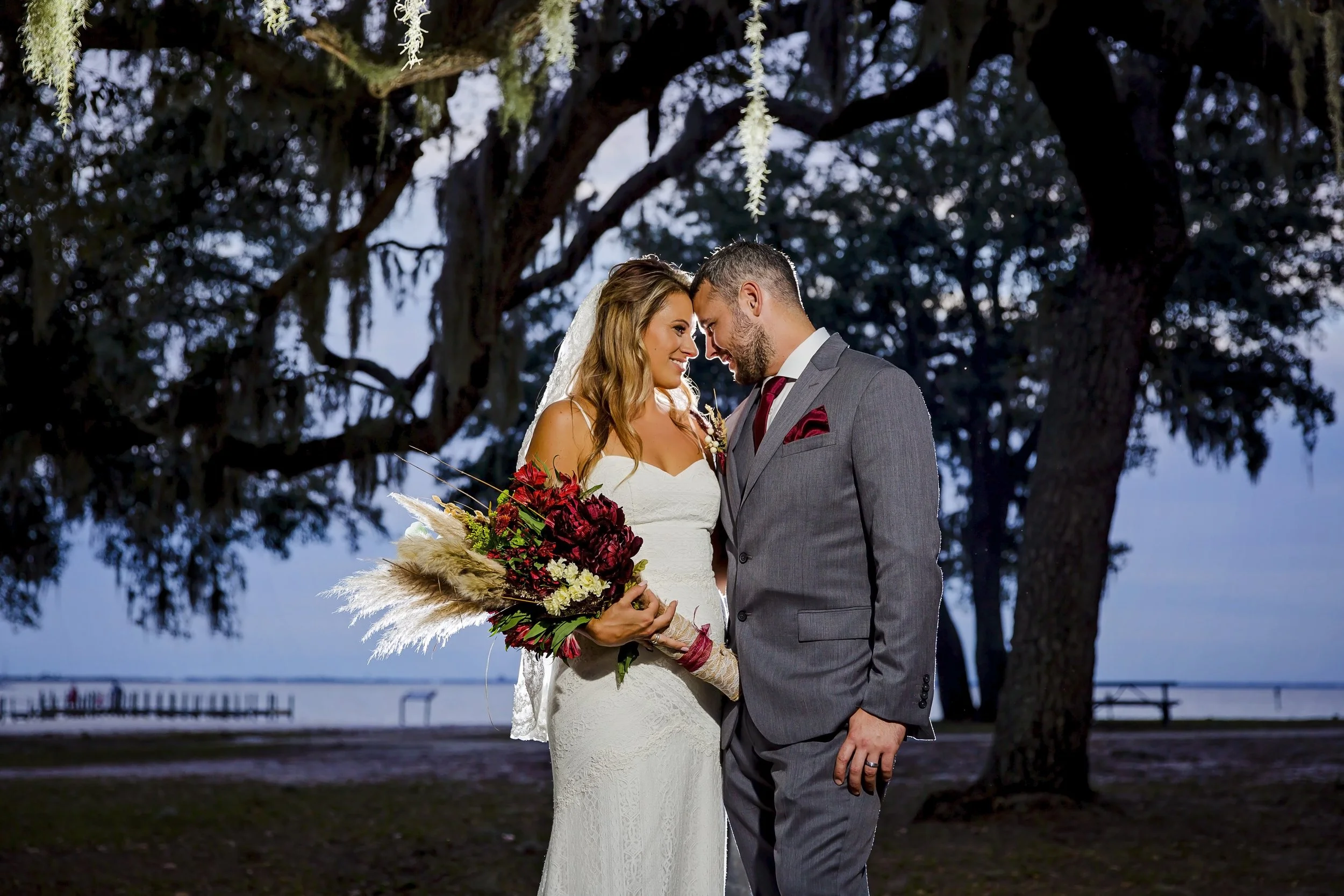 Bride and groom looking at each other standing under trees in design Florida. Photographed by a Jacksonville St. Augustine beach photographer