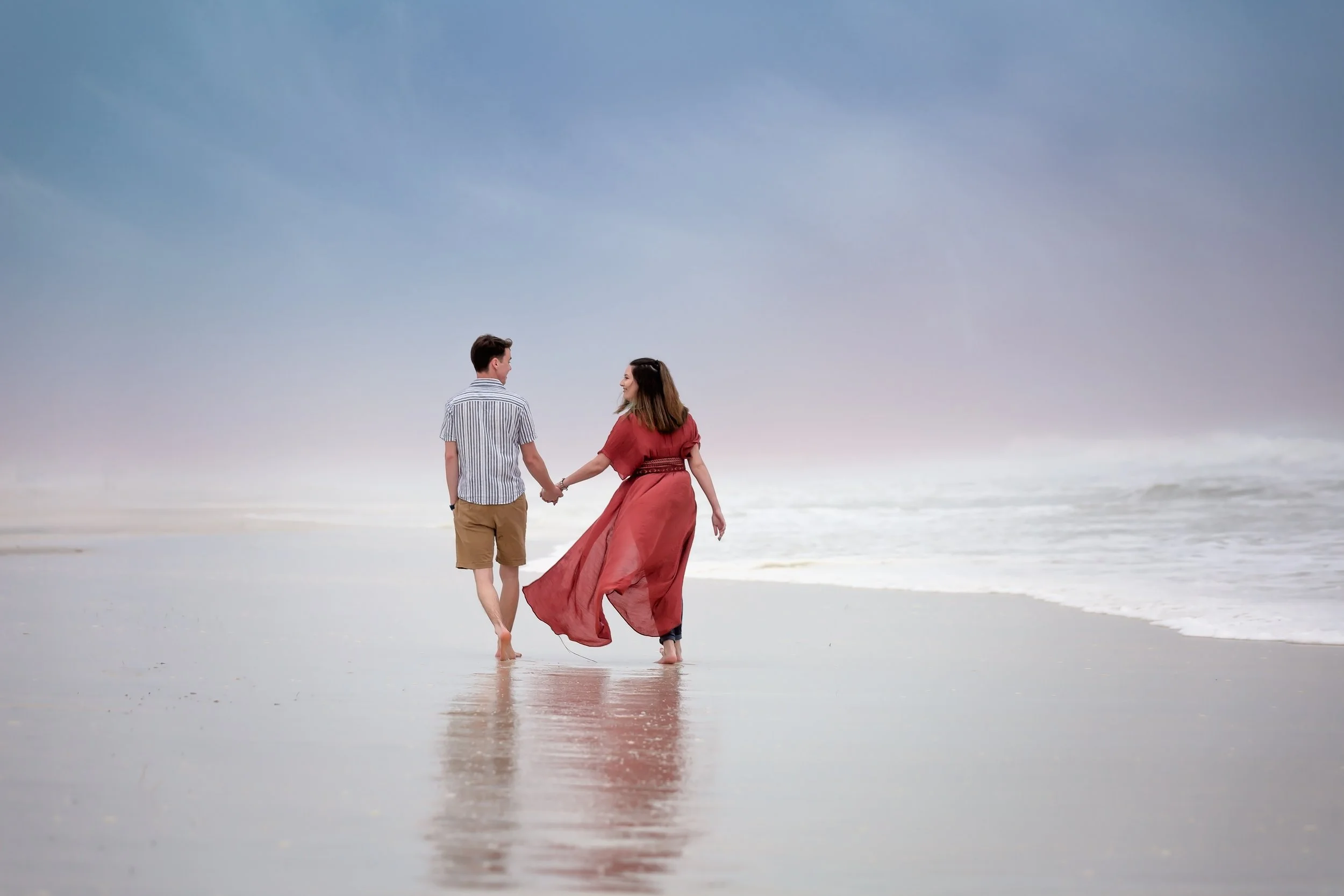 Photo of engaged couple walking on the Jacksonville Beach