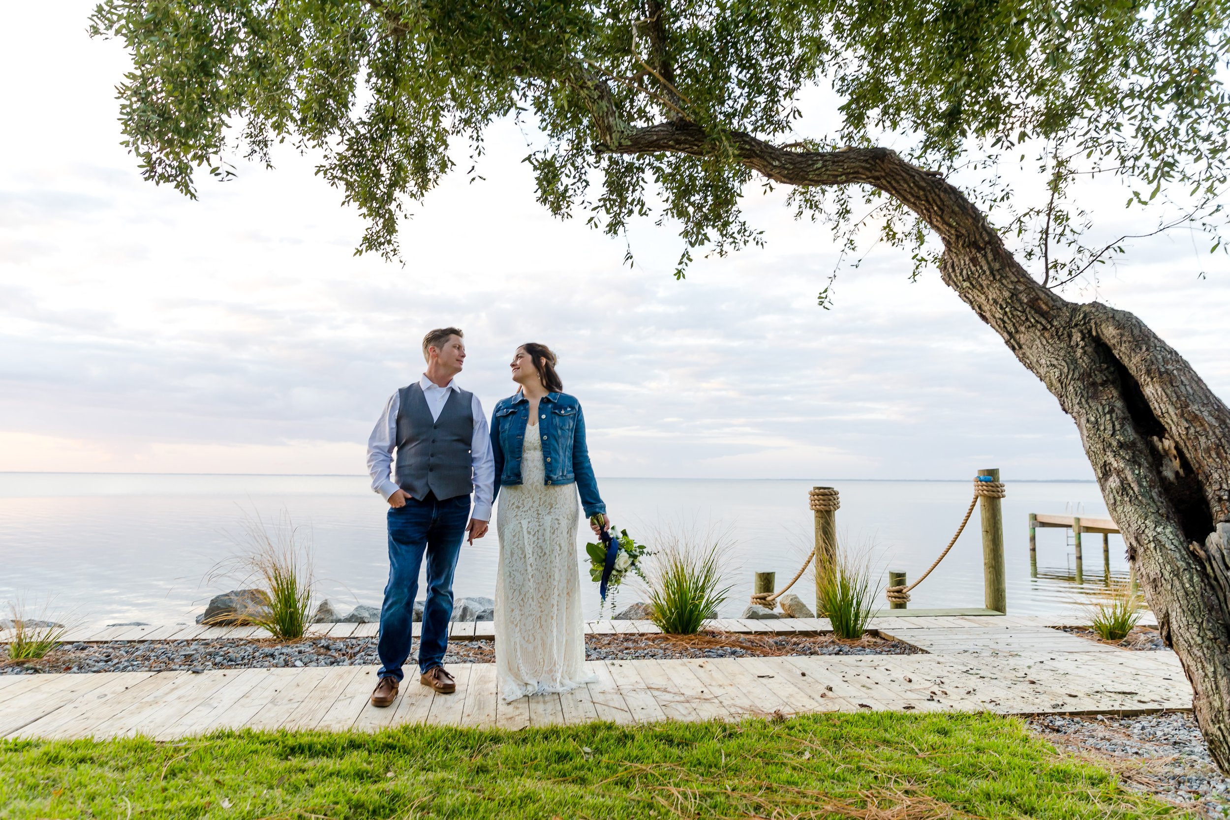 Bride and groom standing under a tree with the bay waters behind them photographed by a Jacksonville Florida St.Augustine wedding photographer