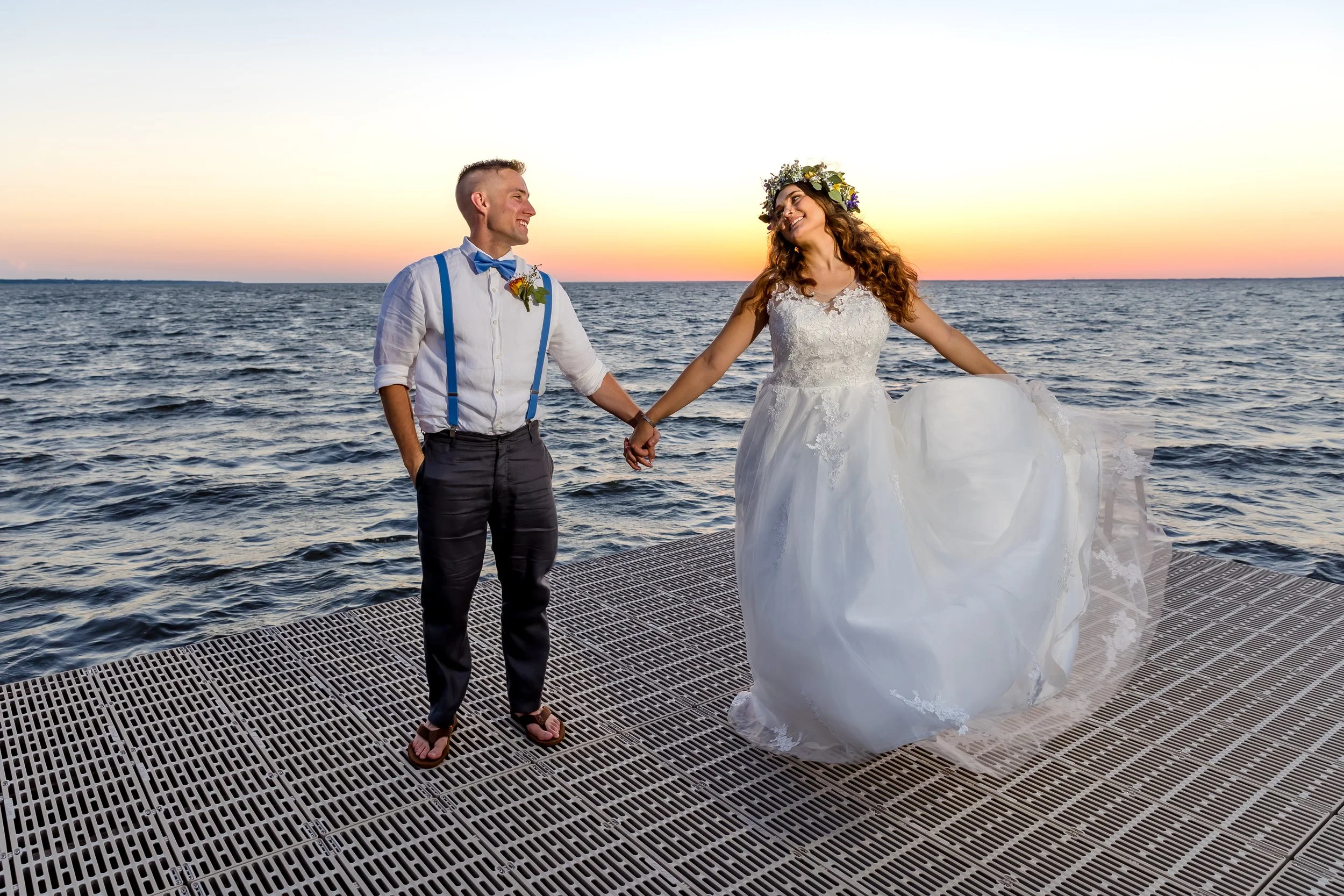 Bride and groom walking on a dock towards a sun set lit sky photo taken by St. Augustine and Jacksonville beach photographer