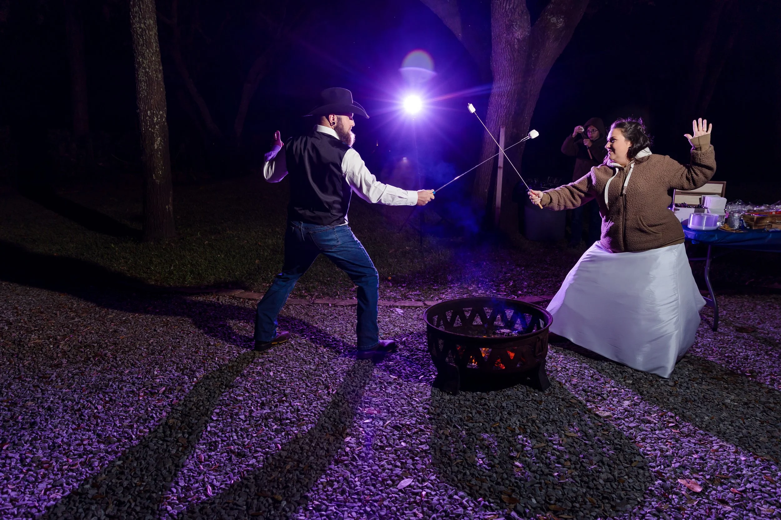 a moment by the campfire share by the bride and groom on the lawn at the Bay Front Lodge and Log Cabin in Gulf Breeze picture taken by Jacksonville Beach and St. Augustine Wedding Photographer