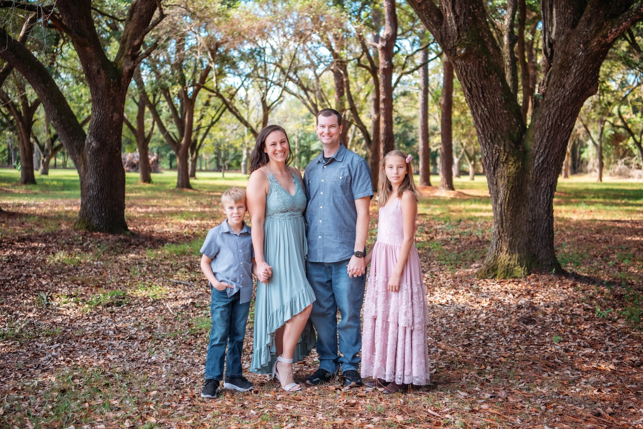 Christy of Inspired By You Photography with her husband and children, serving clients as a Navarre Beach family photographer.