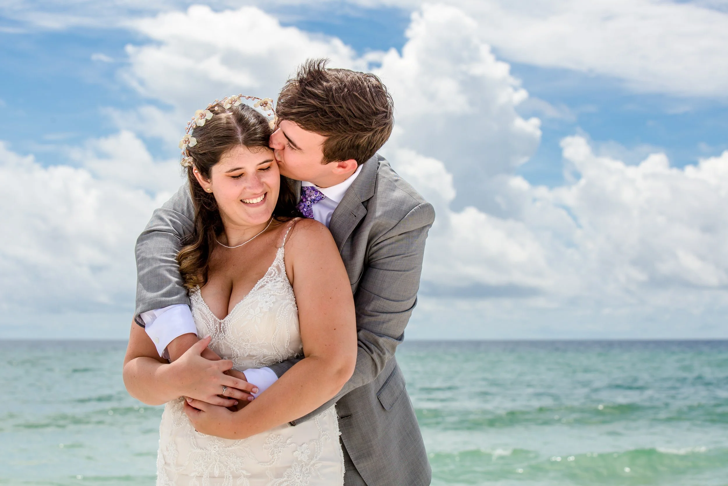 Bride and groom embrace on  Navarre beach taken by Jacksonville beach and St. Augustine Florida Photographer
