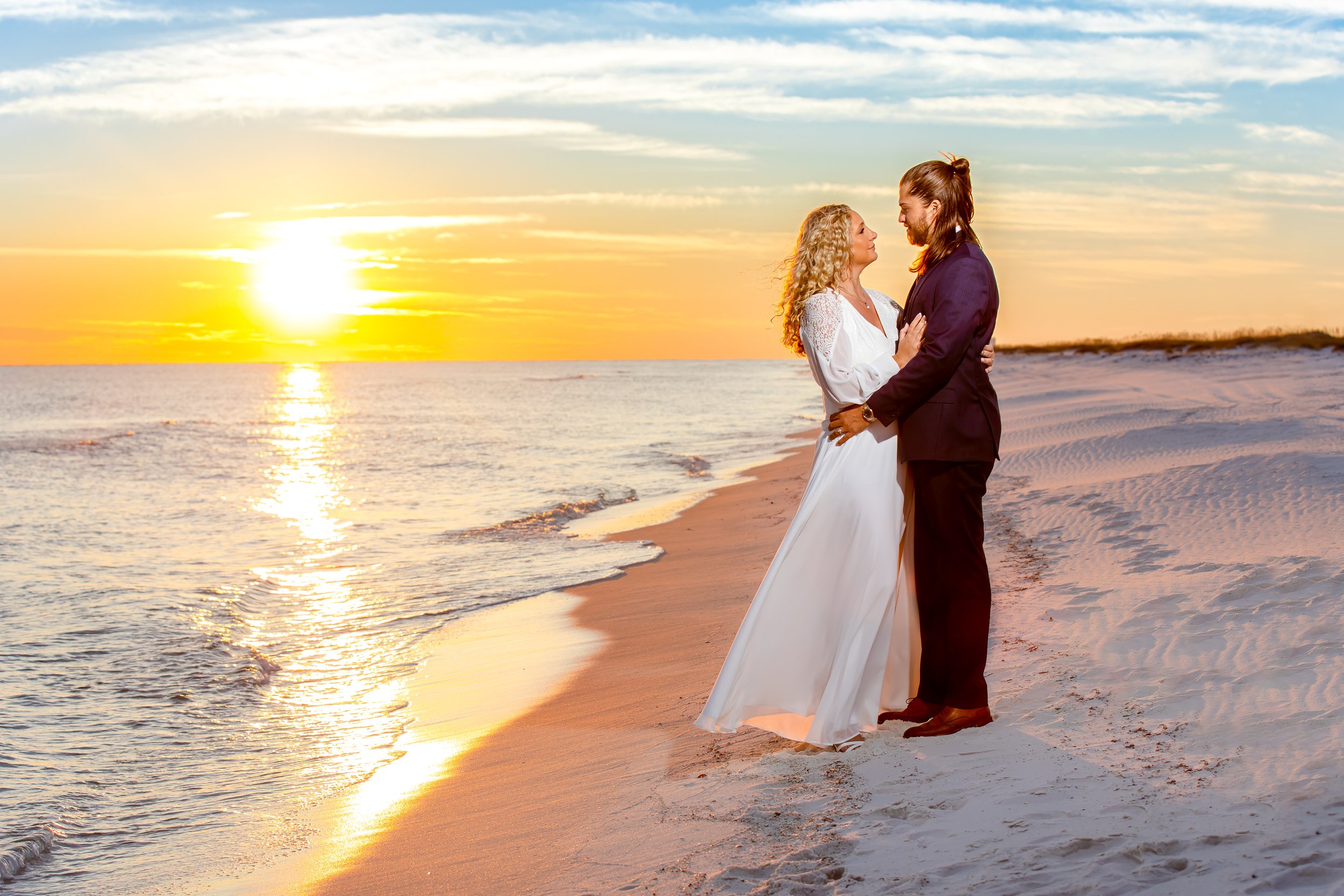 Navarre Beach wedding couple at sunset by Inspired By You Photography, a wedding photographer serving Navarre and the Florida Gulf Coast.