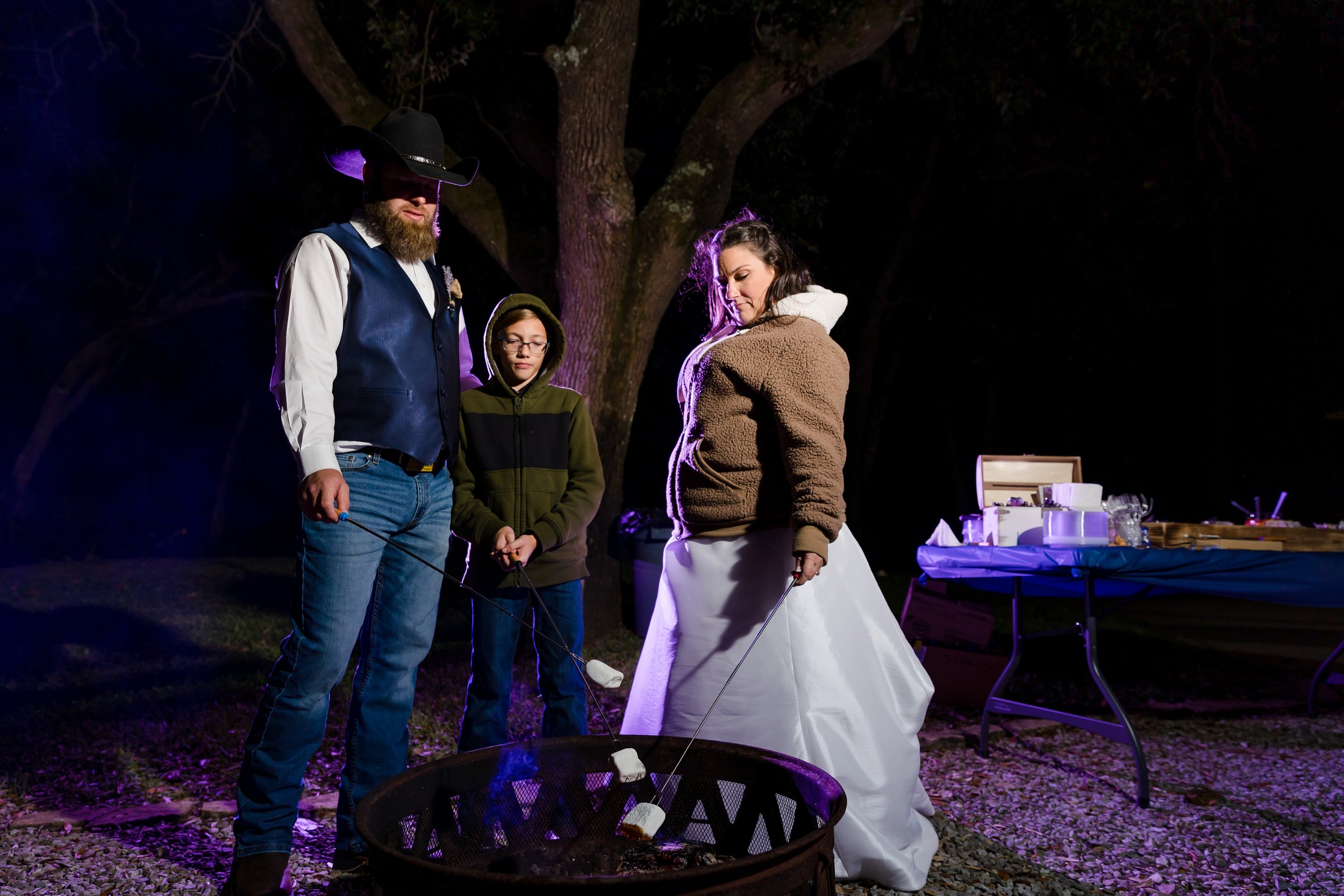Family gathered by a campfire on the lawn at the Bay Front Lodge and Log Cabin in Gulf Breeze picture taken by Jacksonville Beach and St. Augustine Wedding Photographer