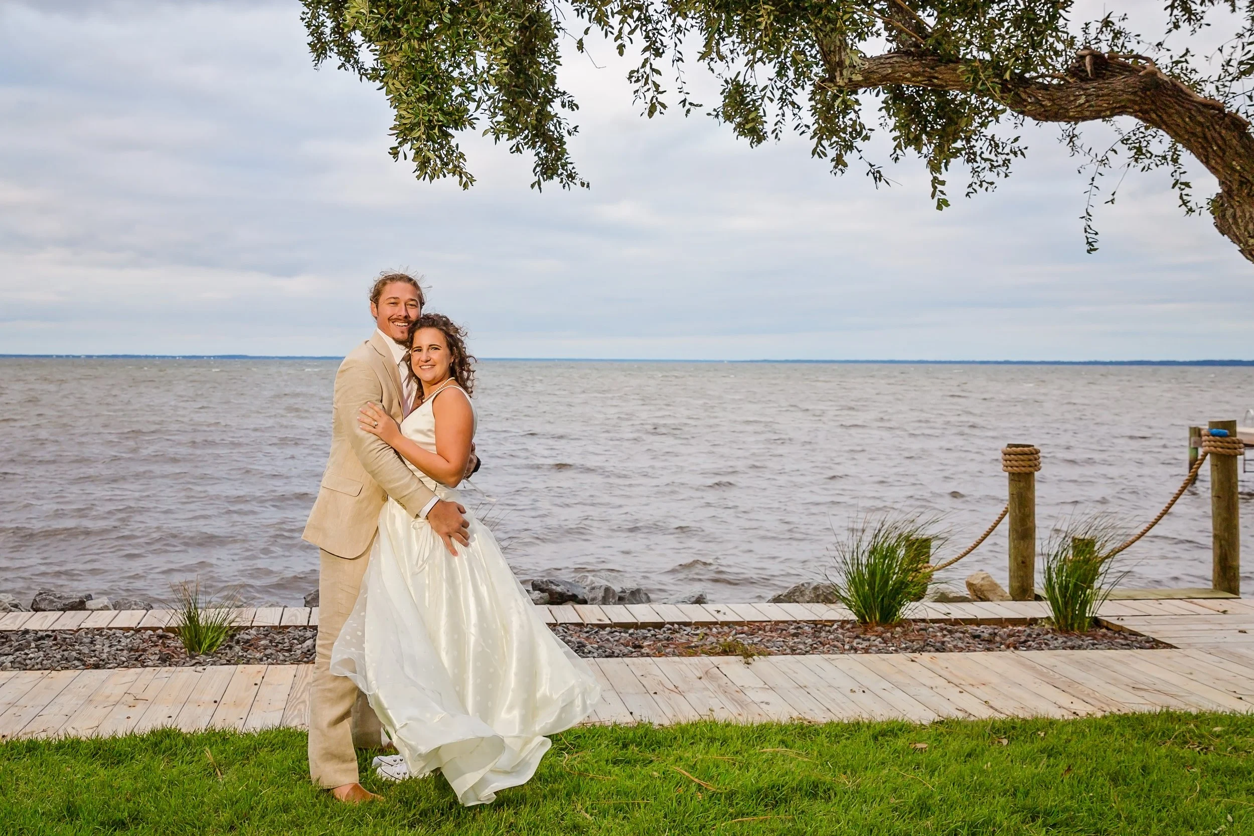 Bride and Groom hugging under a tree at the Bay Front Lodge and Log Cabin in Gulf Breeze Florida photographed by Jacksonville beach and St. Augustine Florida photographer