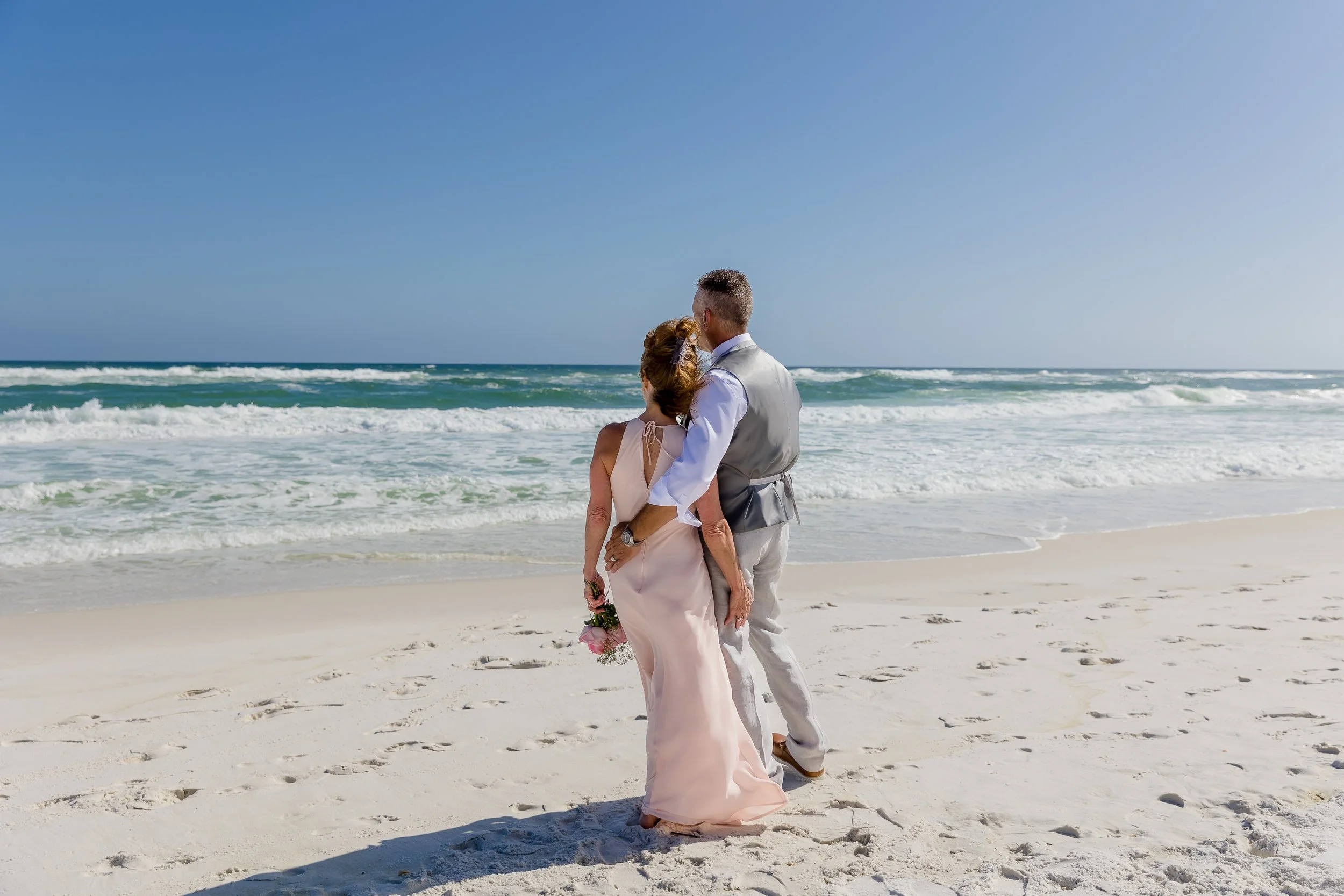 Beautiful sunny Florida beach day with a beautiful Bride and groom standing next to each other captured by Jacksonville beach and St. Augustine Wedding photographer