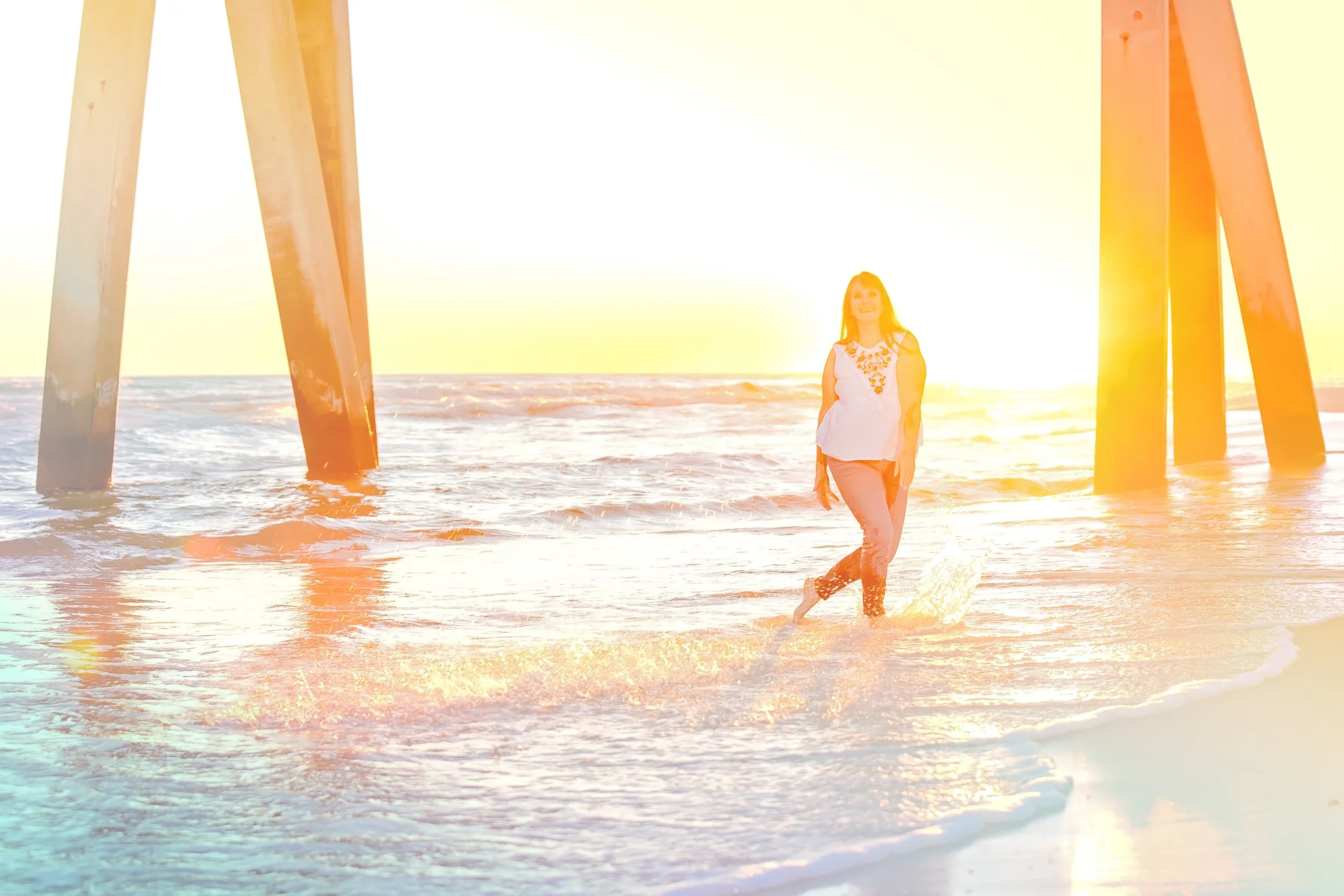 sunset images with a woman splashing in the waters of Jacksonville beach Florida