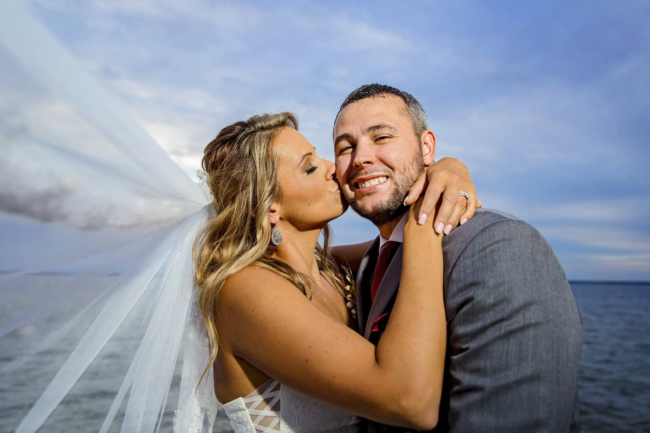 bride kissing grooms cheek photographed by a Jacksonville St. Augustine beach photographer