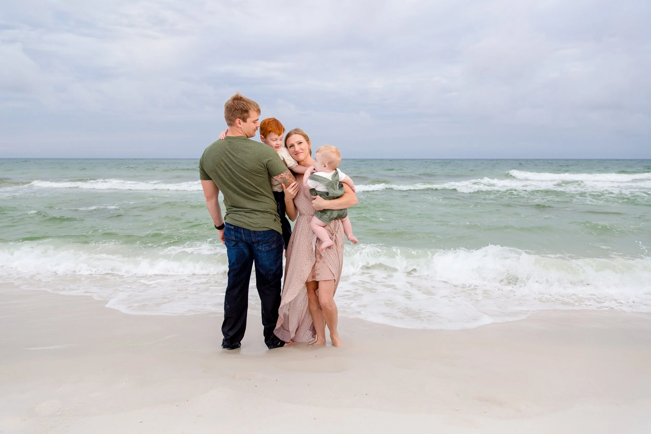Family of four on the beach by Inspired By You Photography, a Navarre Beach family photographer specializing in family vacation photos.