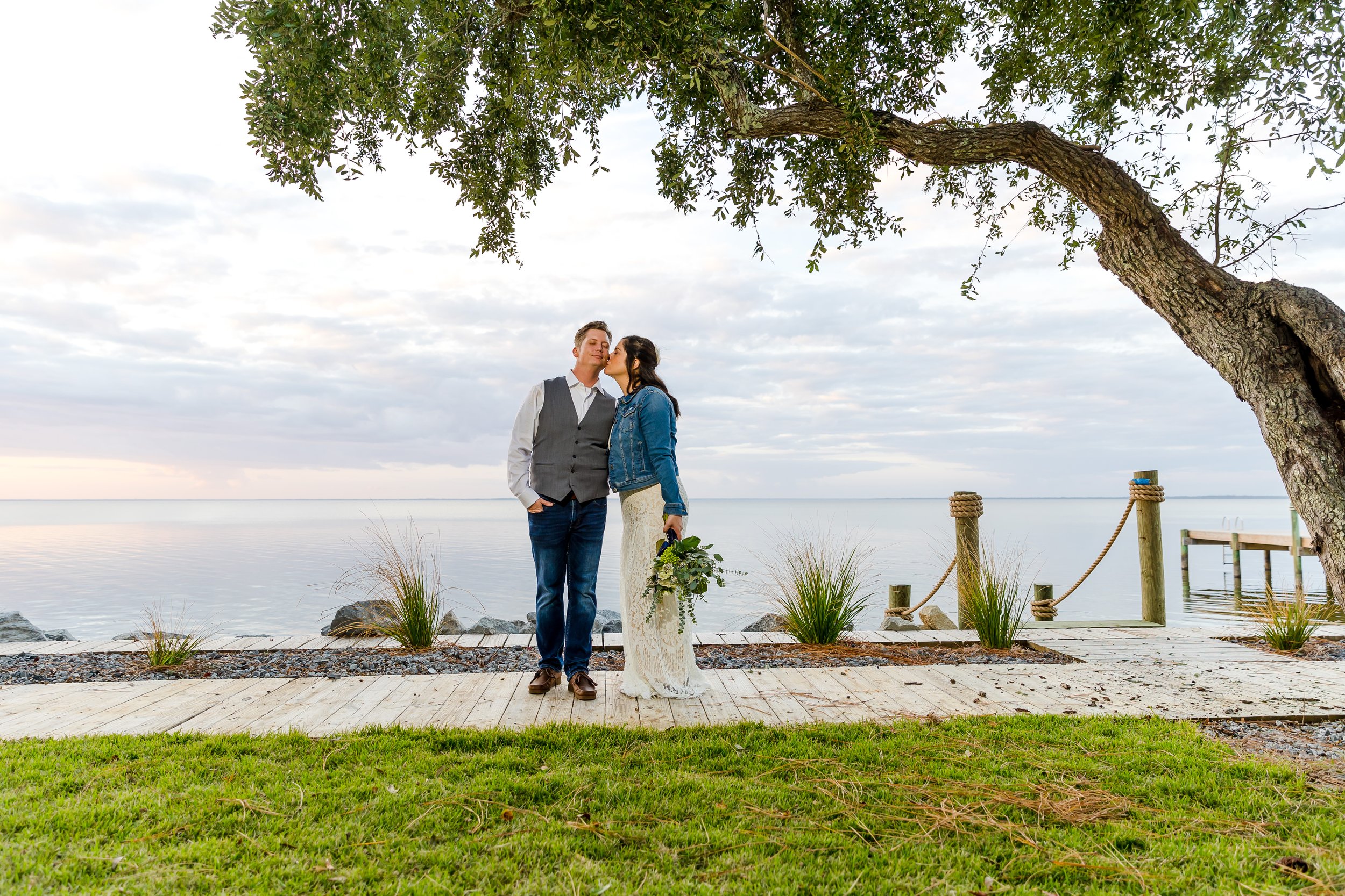 Bride and groom standing under a tree with the bay waters behind them photographed by a Jacksonville Florida St.Augustine wedding photographer