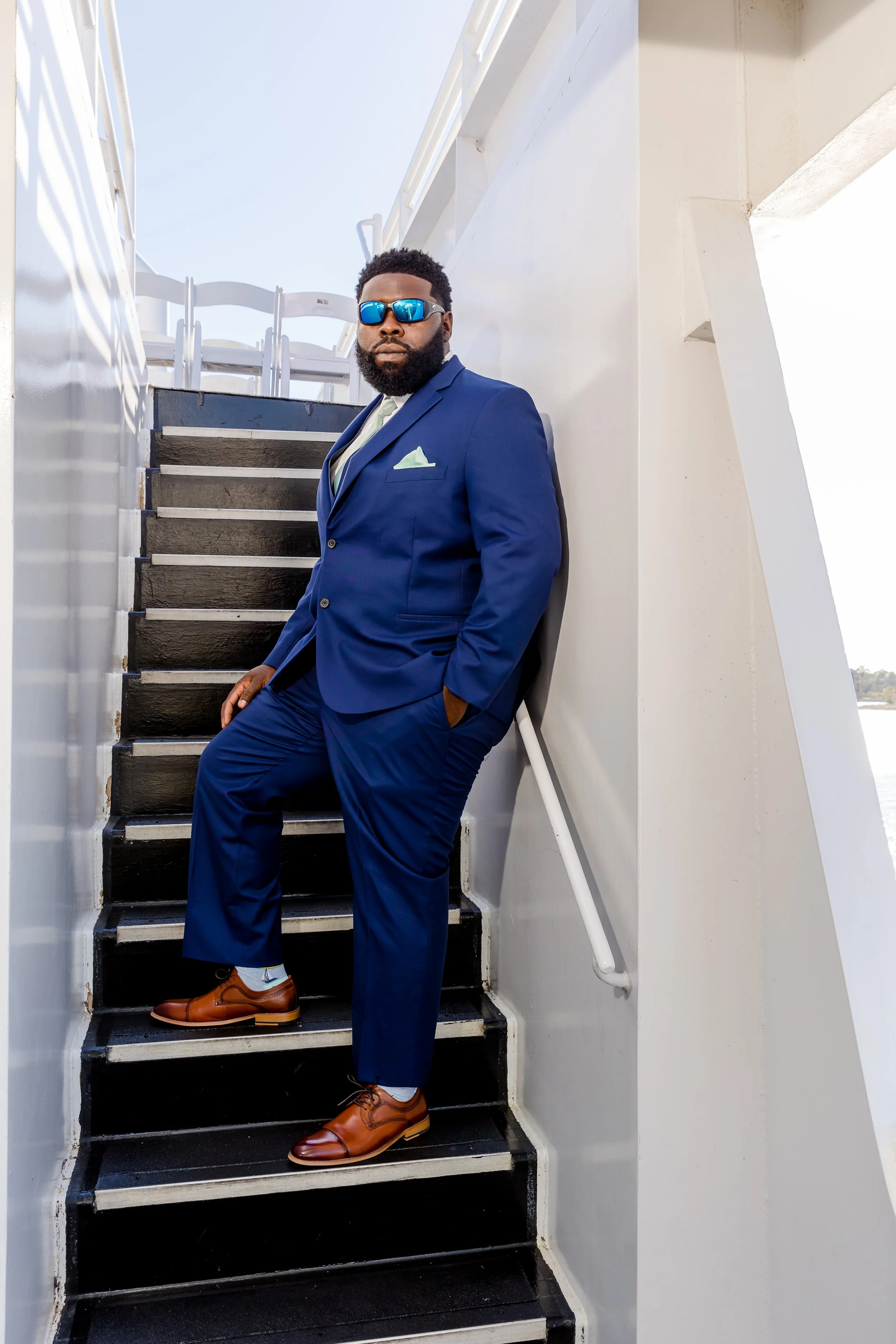 Handsome groom standing on the top deck of a yacht at sunset  photo taken by Jacksonville-Florida St.Augustine-wedding-photographer