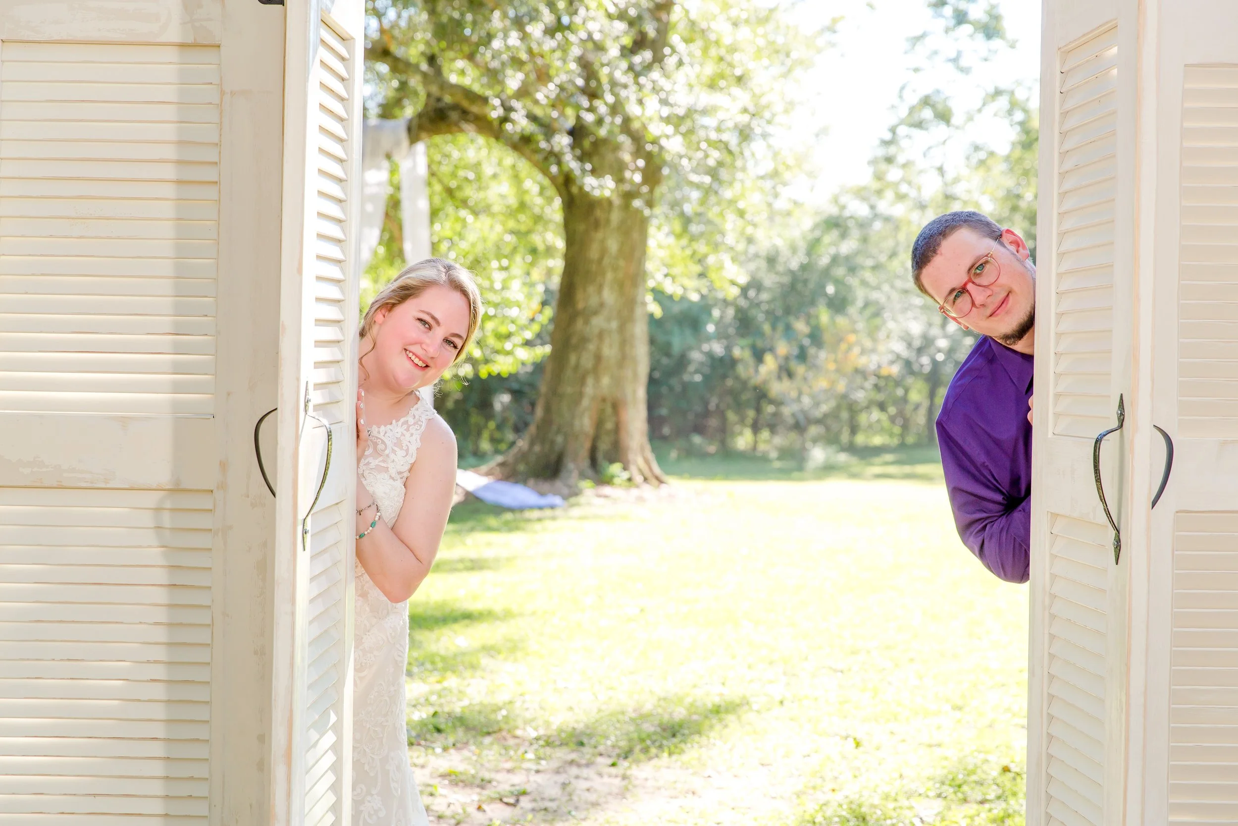 Bride and groom country wedding standing by a wooden door holding hands taken buy a St. Augustine and Jacksonville wedding photographer