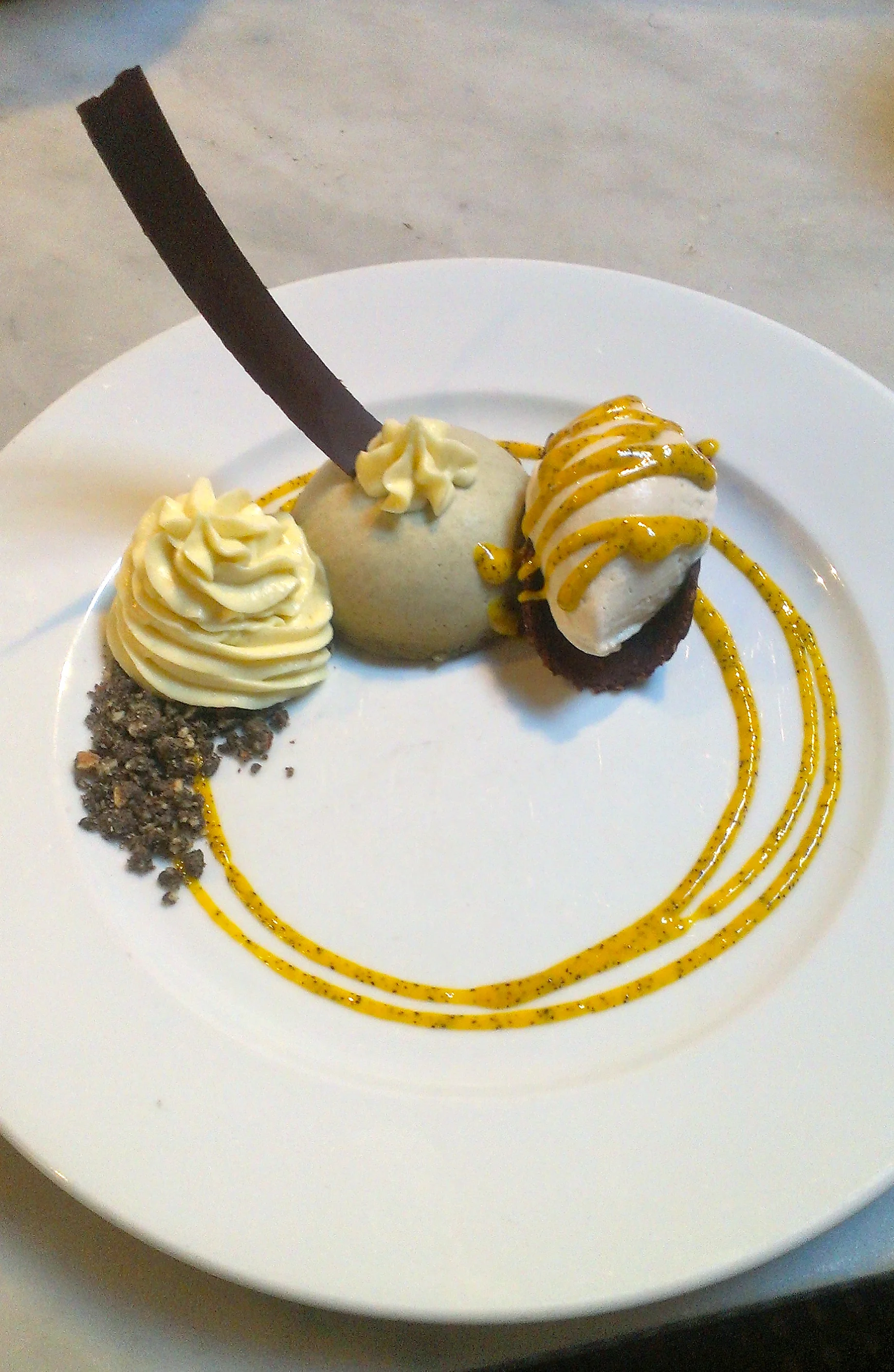 lemongrass mousse atop lemongrass cake, black sesame streusel, pineapple whip, coconut-banana ice cream in a chocolate-coconut tuille, passionfruit coulis (raw, gluten-free)