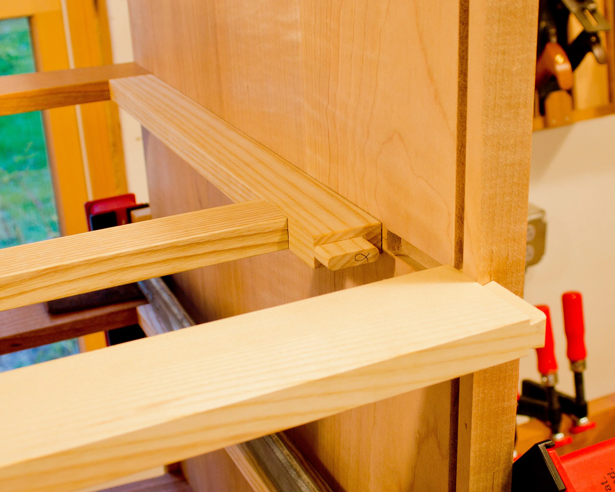 One of the rear horizontal dividers awaiting it's turn with the clamps. You can see the tenon on the end of the runner, which fits into a corresponding mortise in the divider.