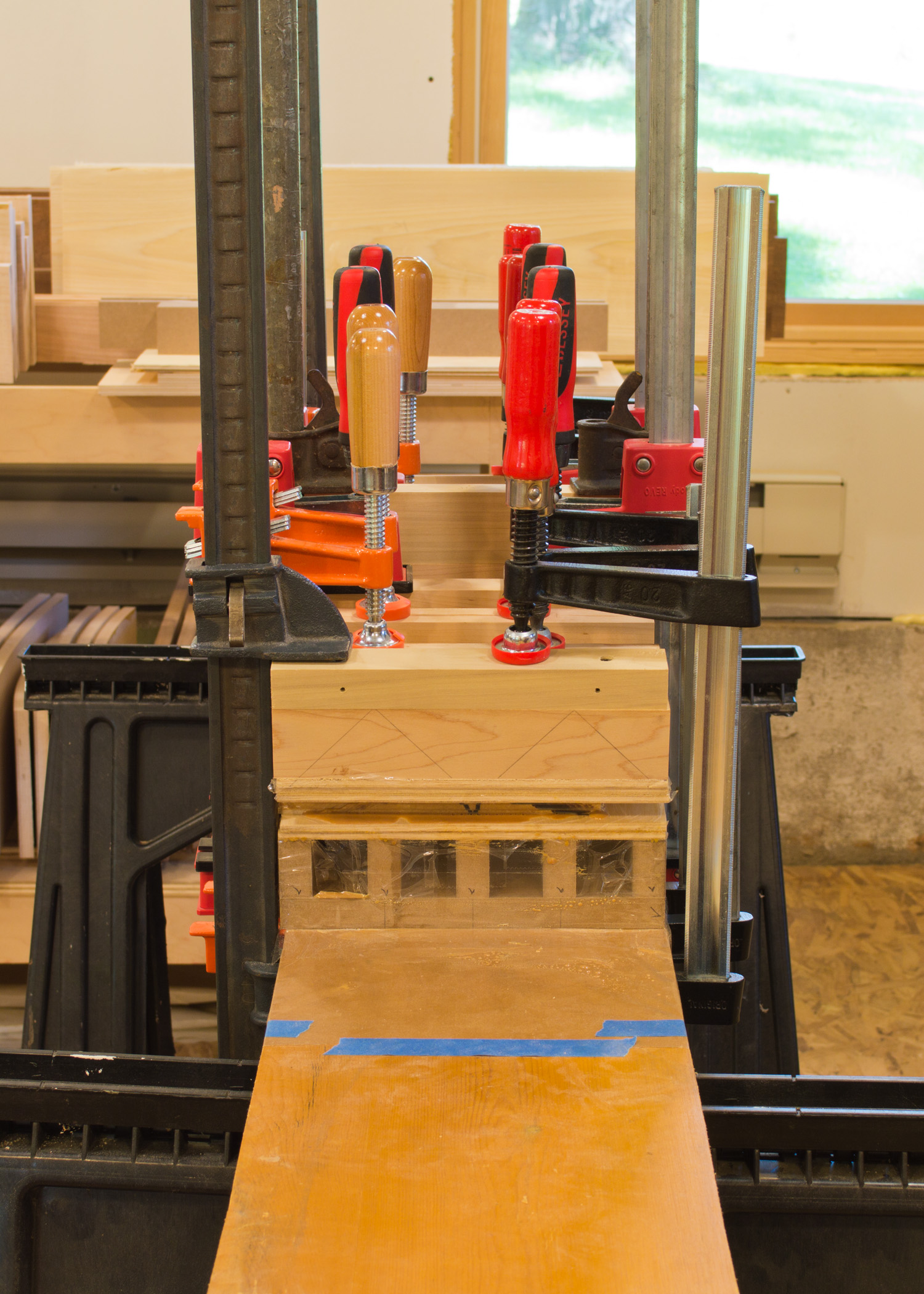  Another view of the same glue-up. &nbsp;The triangles drawn on the maple clamping cauls illustrate how the force exerted by each clamp transfers through the caul to create even clamping pressure. &nbsp;The row of clamps on the right side are offset 