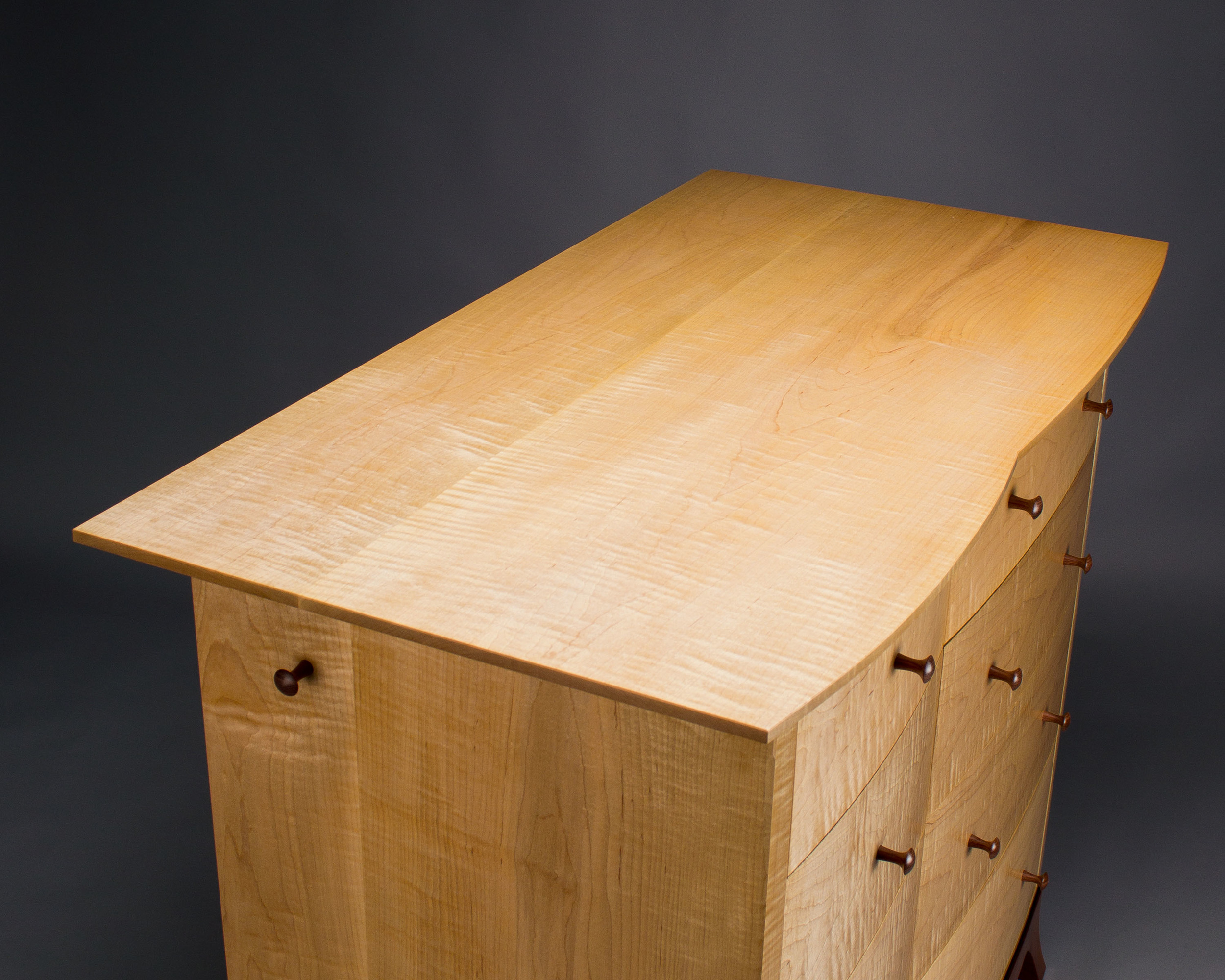  The top of the chest is curved to mirror the curves of the drawer fronts. 