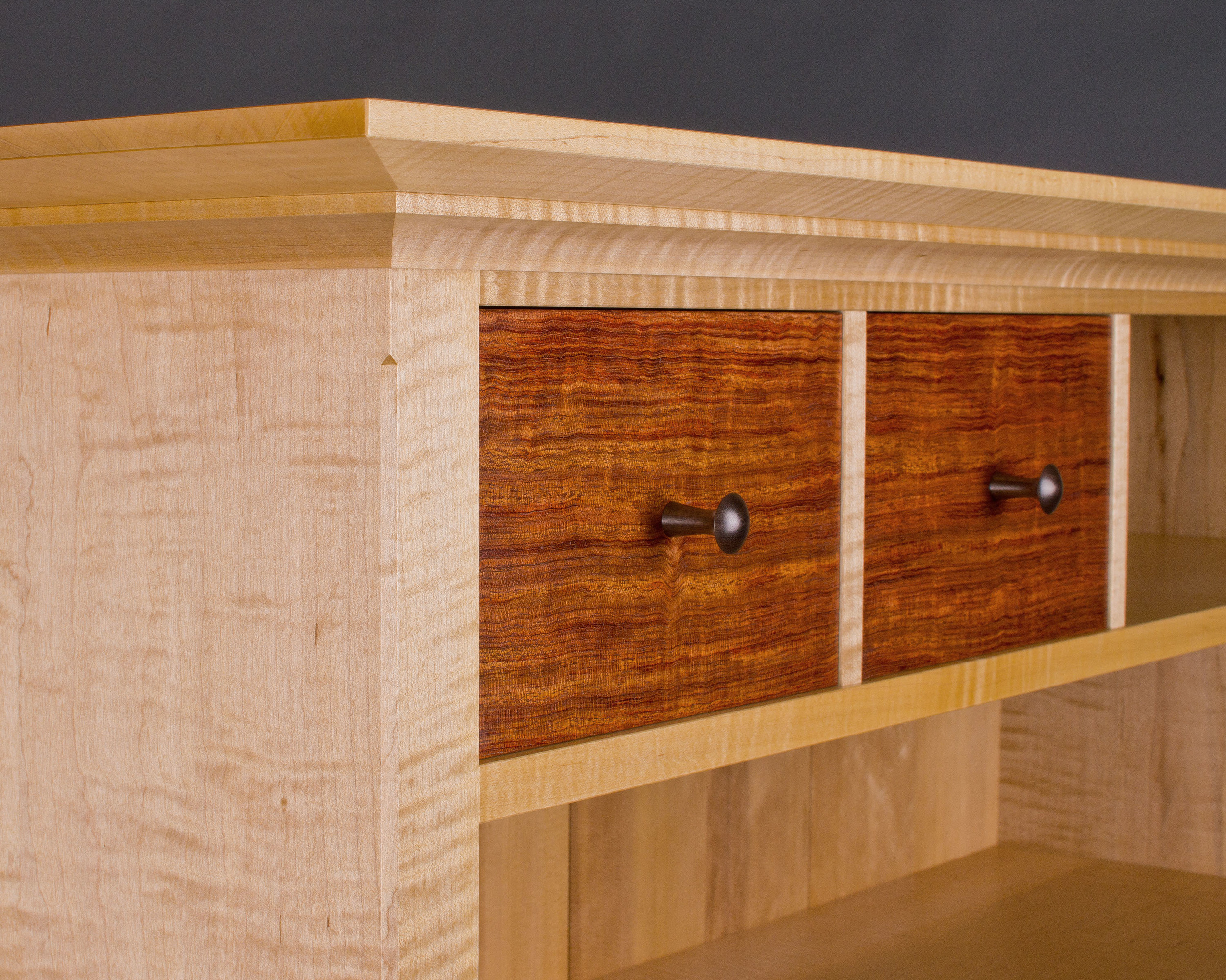 off-center drawer fronts are made of bubinga, with hand-turned rosewood knobs