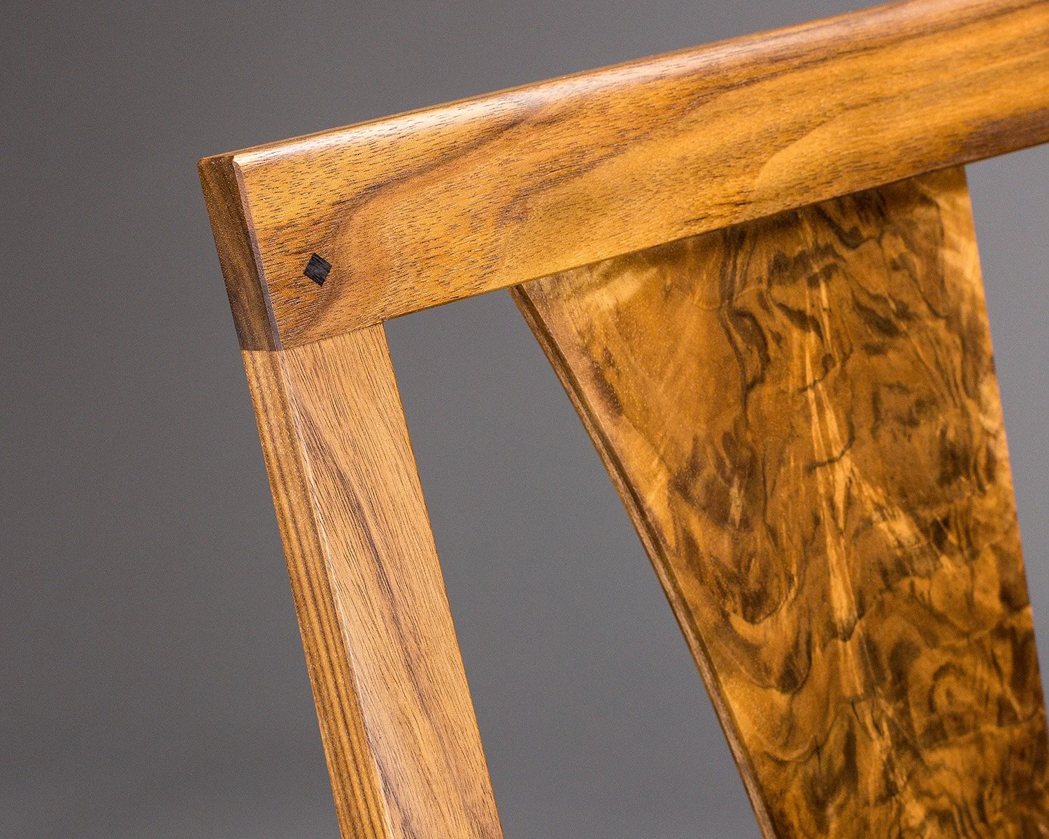 Joinery detail of a custom designed black walnut dining chair showing fine craftsmanship.