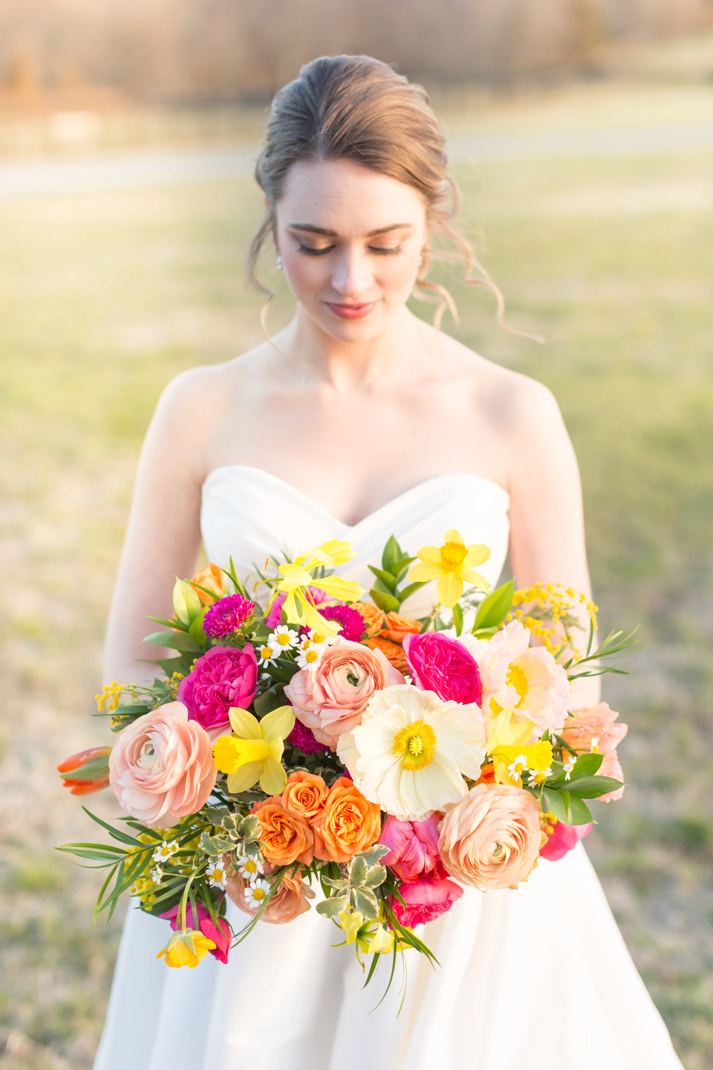 Spring bridal bouquet of daffodil, ranunculus, garden rose, tulips, gloriosa lily, mimosa 