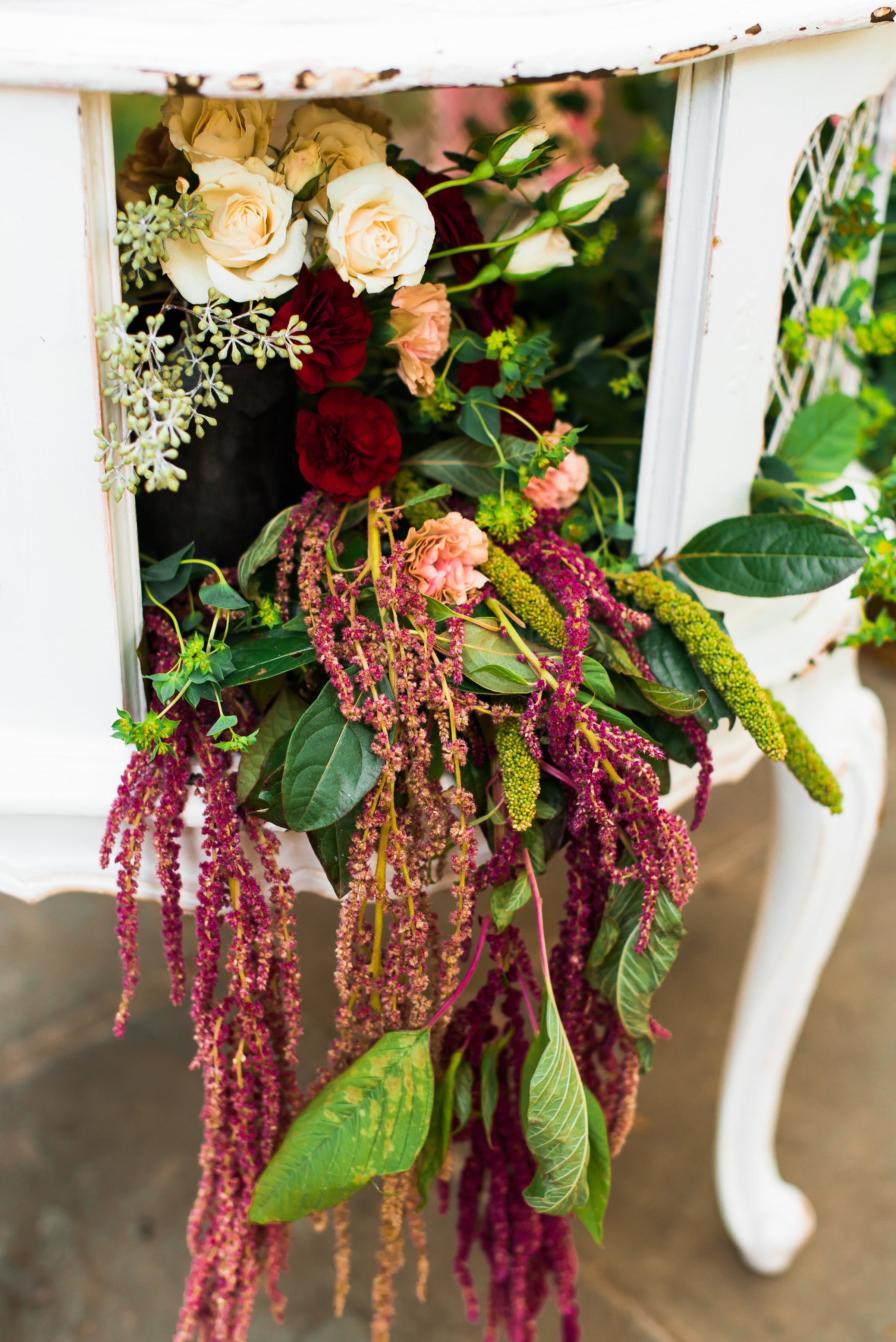 Flowers spilling out of antique table 