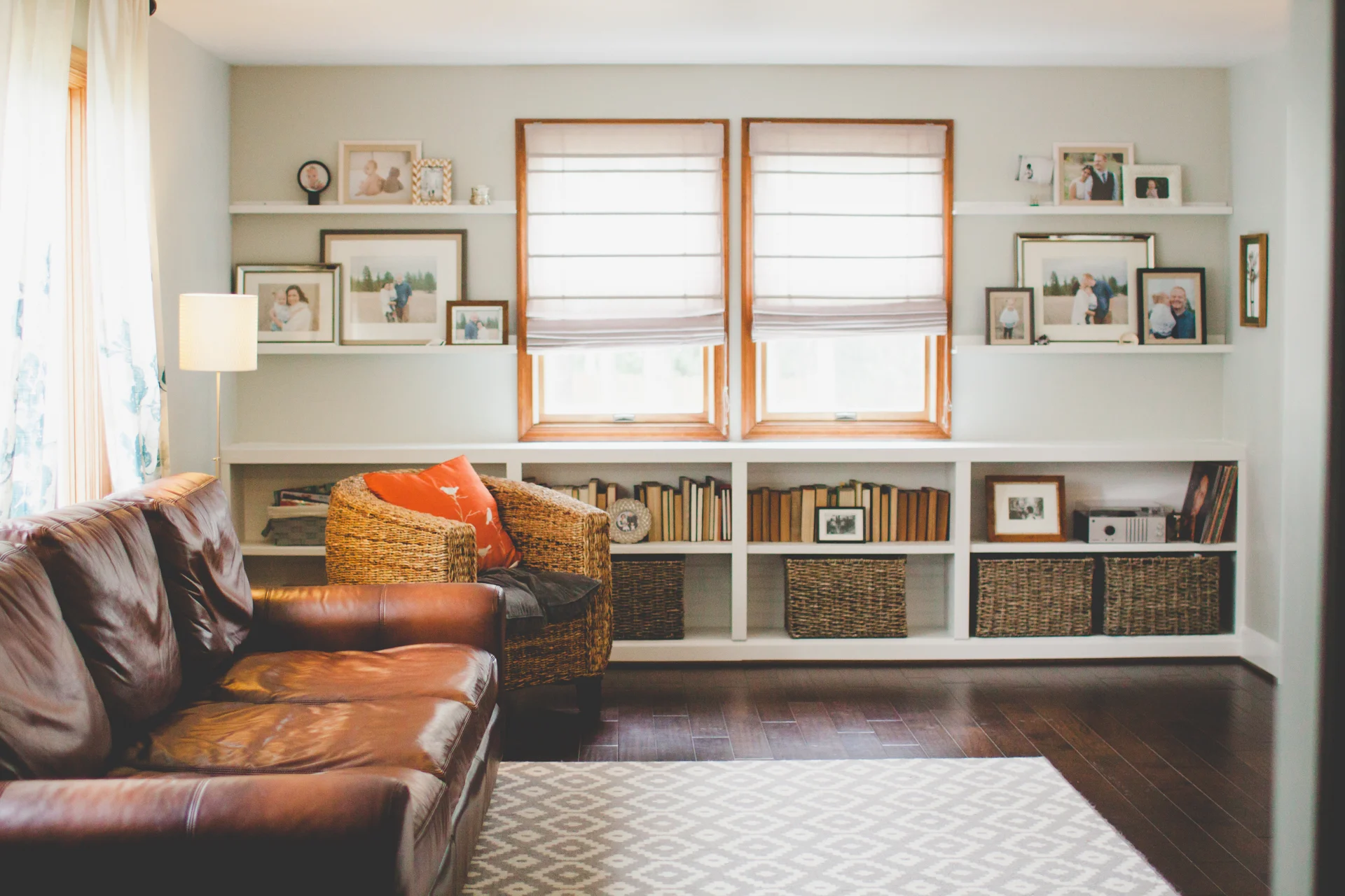 AFTER: oh hello light! New floors, paint and window treatments. Donald build the bookshelves and floating ledges. Also my coveted pottery barn oversize couch. yeses.