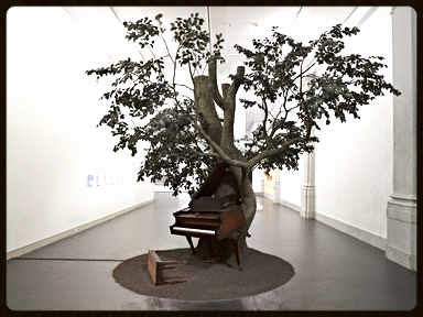 Sanford Biggers, Blossom "In Blossom , a piano inexplicably fused with a tree plays "Strange Fruit" (in an arrangement by the artist). The song, popularized in the 1930s by Billie Holiday, protests the atrocity of lynching: "Southern trees bear