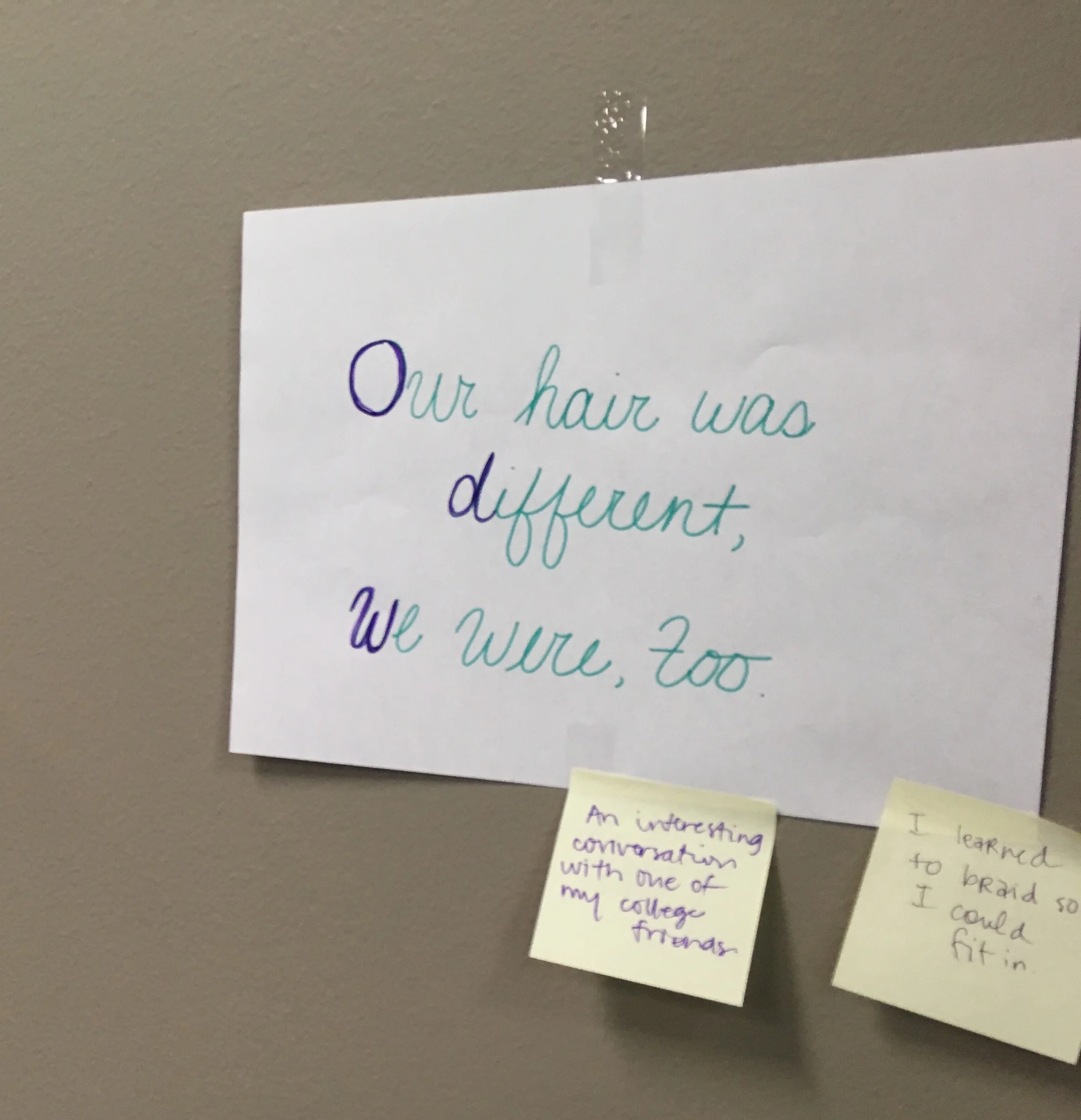 a paper with the words, “Our hair was different, were, too,” and two sticky notes below it.