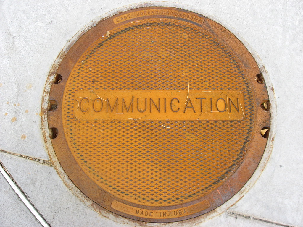 an orange manhole cover with the words ‘Construction’ on top.