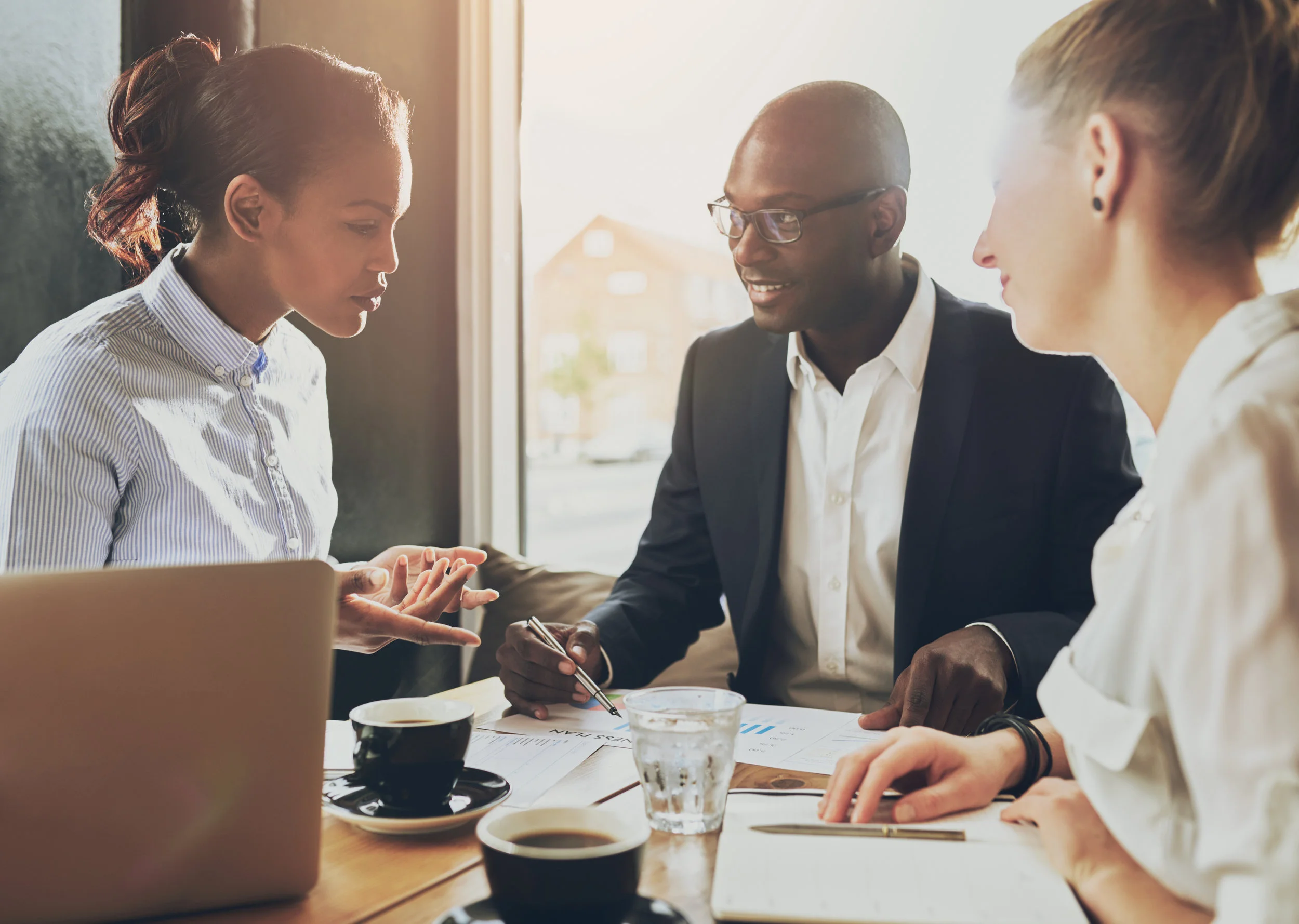 Three people sit at a table working productively and drinking what appears to be delicious coffee. Clearly, the meeting facilitator has prepared and is in the process of running a super awesome meeting. Dreams really can come true! 