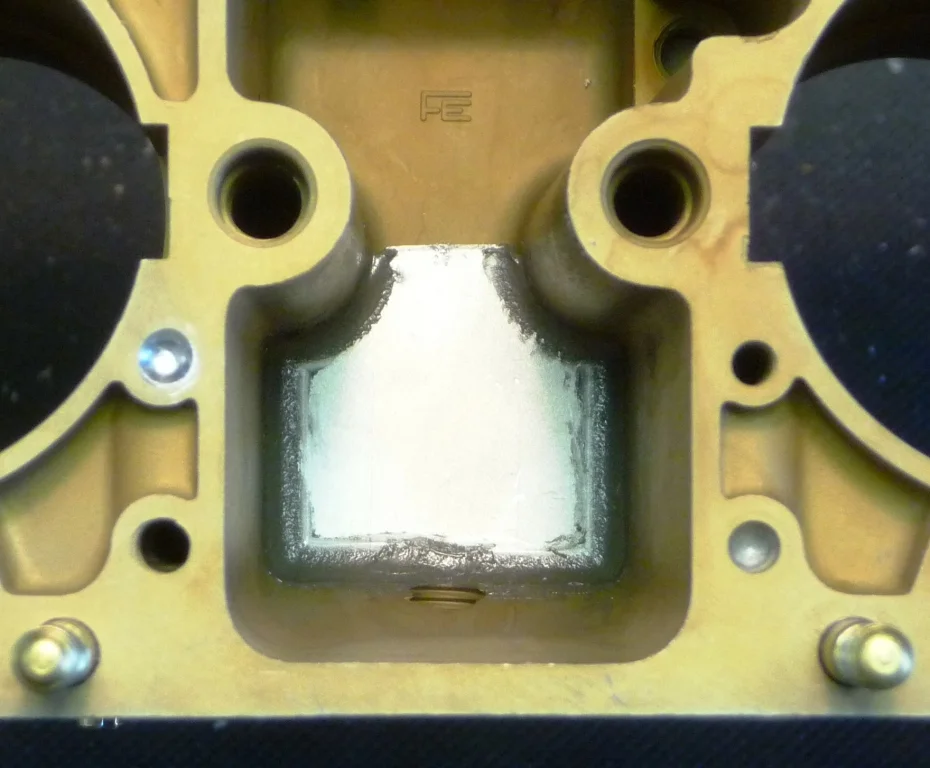Baffle plate installed over main jet carriers after the fuel pick-up points have been milled closer to the floor of the float bowl. Two baffle plates are required per throttle body.