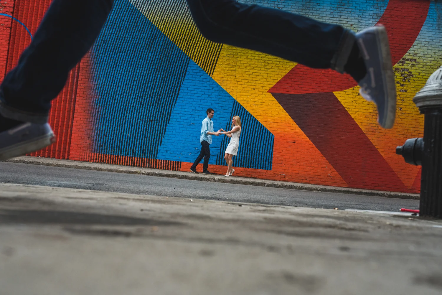 Brooklyn engagement session with a couple walking together near colorful city murals in New York