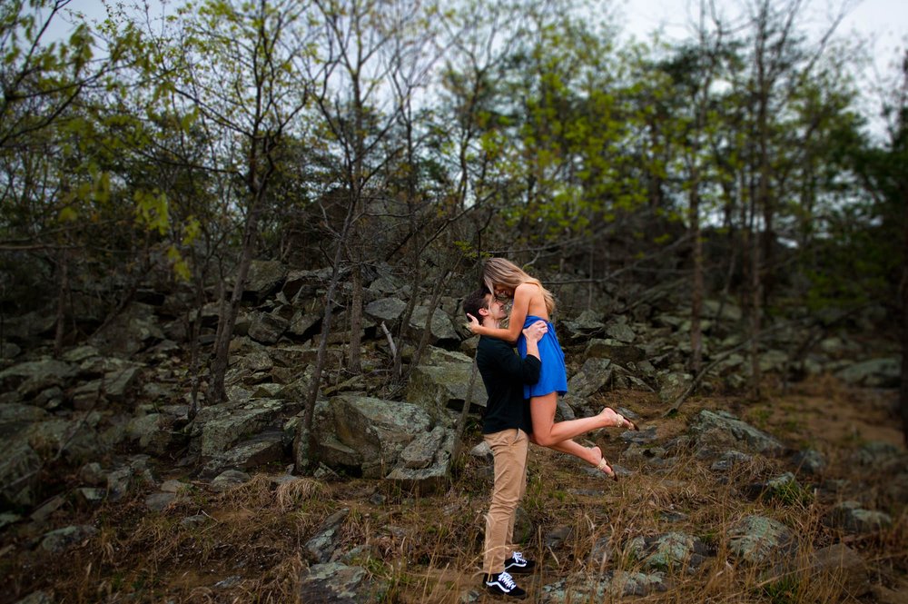  Kyle and Michela, who are celebrating their engagement with a photo session at the Billy Goat Trail. The theme of the session is the summer beach and the couple's journey towards a lifetime of love. It's a joyful and romantic occasion, and the Billy