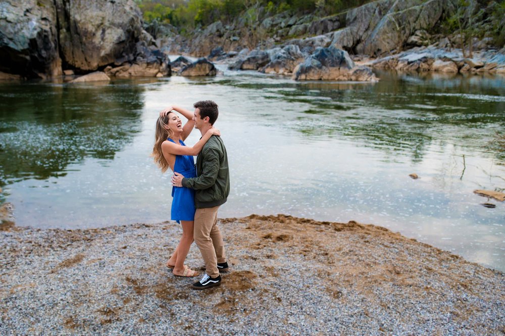  Kyle and Michela, who are celebrating their engagement with a photo session at the Billy Goat Trail. The theme of the session is the summer beach and the couple's journey towards a lifetime of love. It's a joyful and romantic occasion, and the Billy