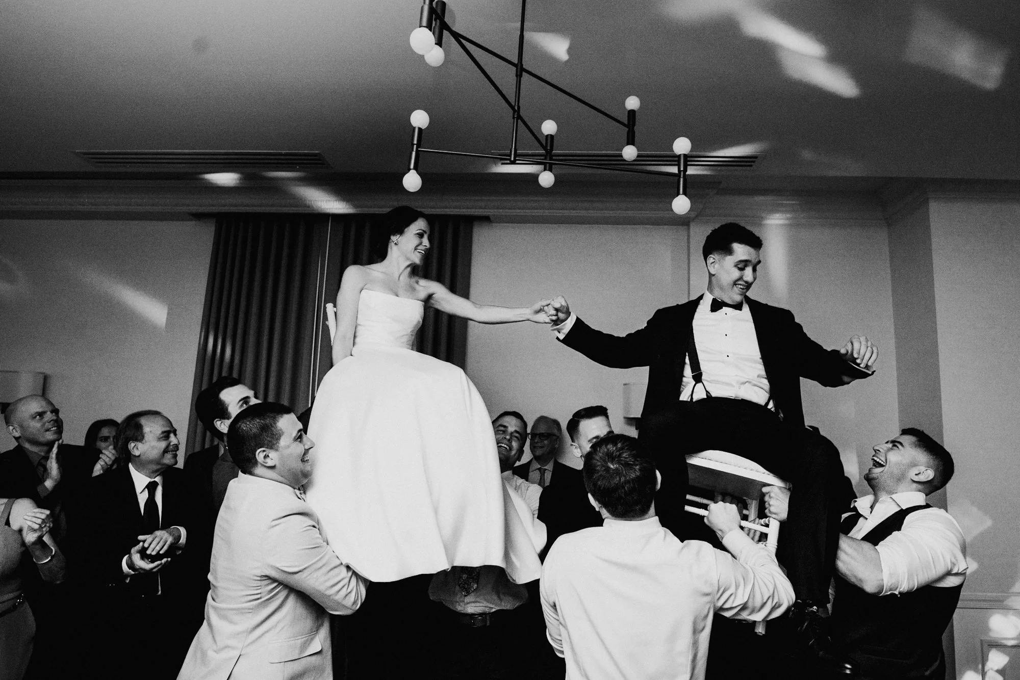 Bride and groom lifted on chairs during a Jewish wedding reception in Washington DC