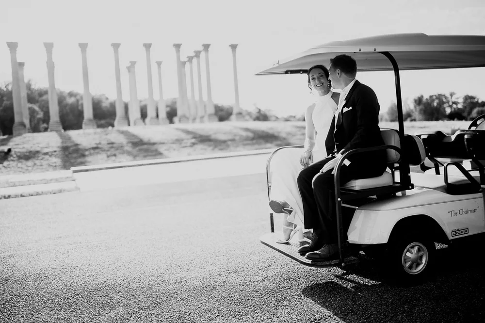 Bride and groom riding a golf cart near the Capitol Columns at a National Arboretum wedding
