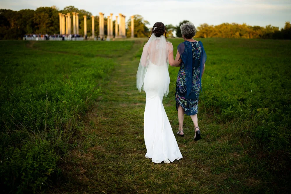 Mother walking the bride down the aisle toward the Capitol Columns at the National Arboretum