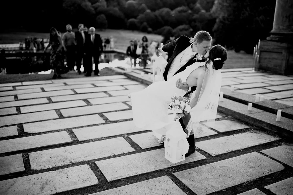 Dramatic black and white wedding kiss on a stone platform near the Capitol Columns