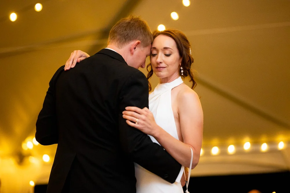 Bride and groom sharing an intimate first dance inside a tented National Arboretum wedding reception