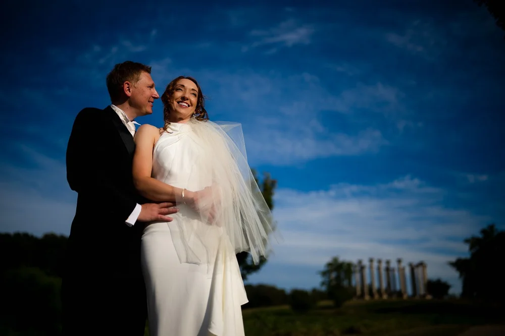 Bride and groom wedding portrait under a bright blue sky at the National Arboretum