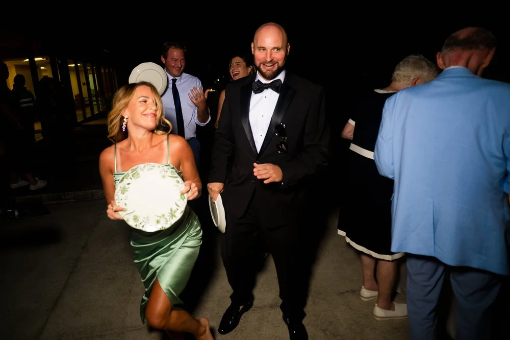 Wedding guest holding a plated dinner during an outdoor National Arboretum reception