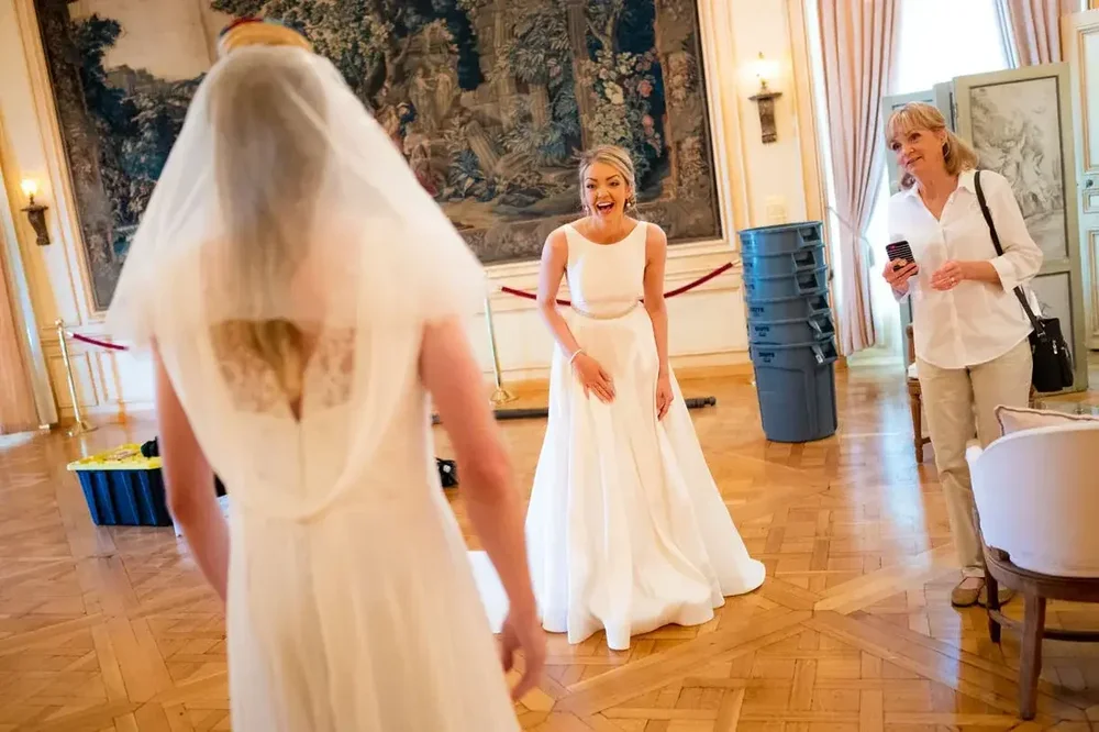 Bride in veil shares a joyful first look moment in the grand hall at Meridian House in DC