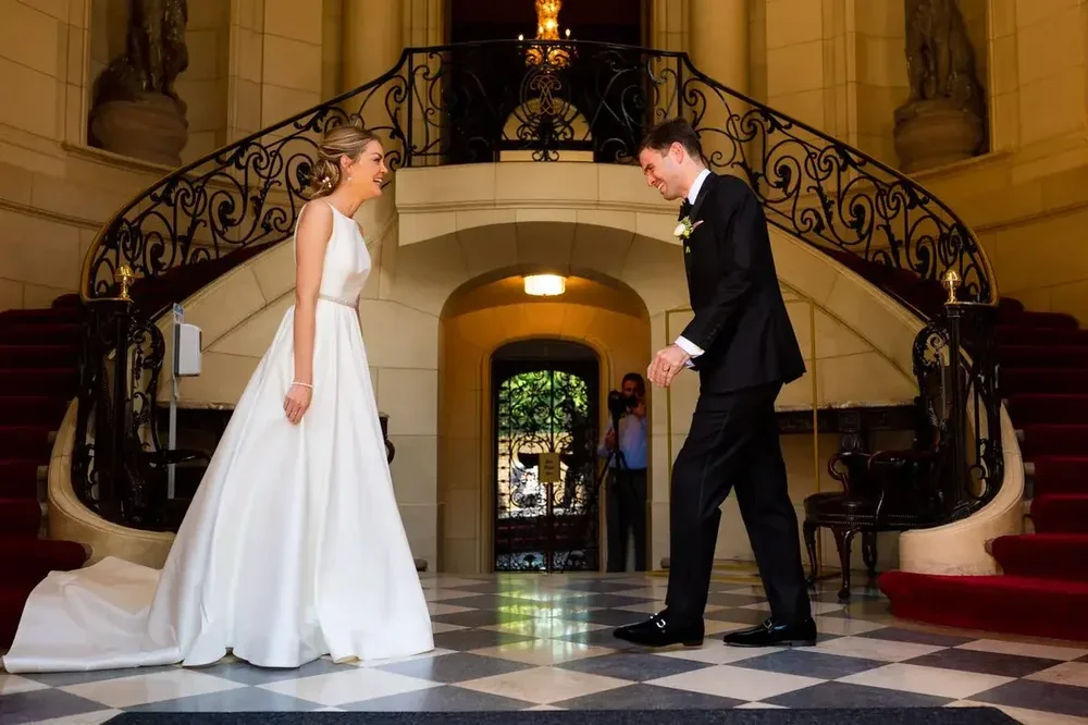 Bride and groom share a first look on the grand staircase at Meridian House