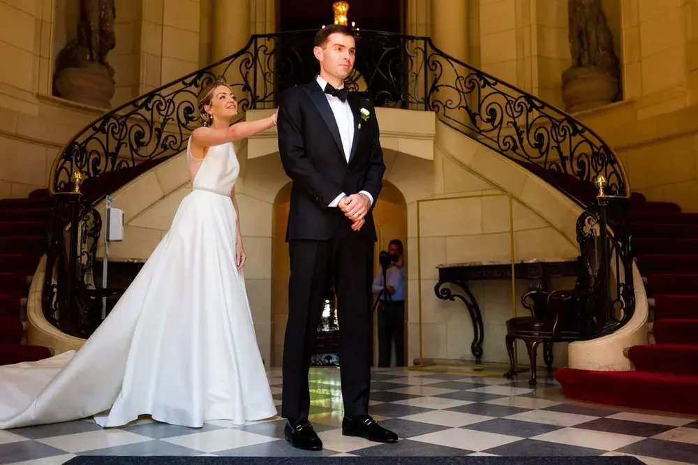 Bride reaches her groom on the grand staircase for their first look at Meridian House in DC