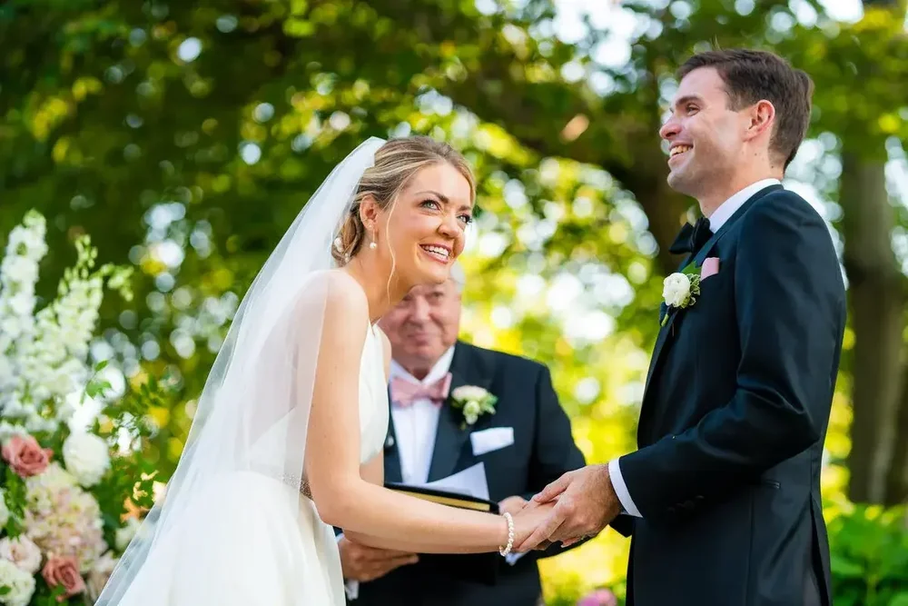 Bride and groom smile while exchanging vows at their outdoor Meridian House wedding