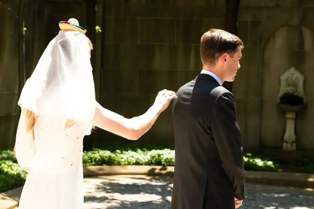 Bride gently touches the groom's shoulder during their emotional first look at Meridian House