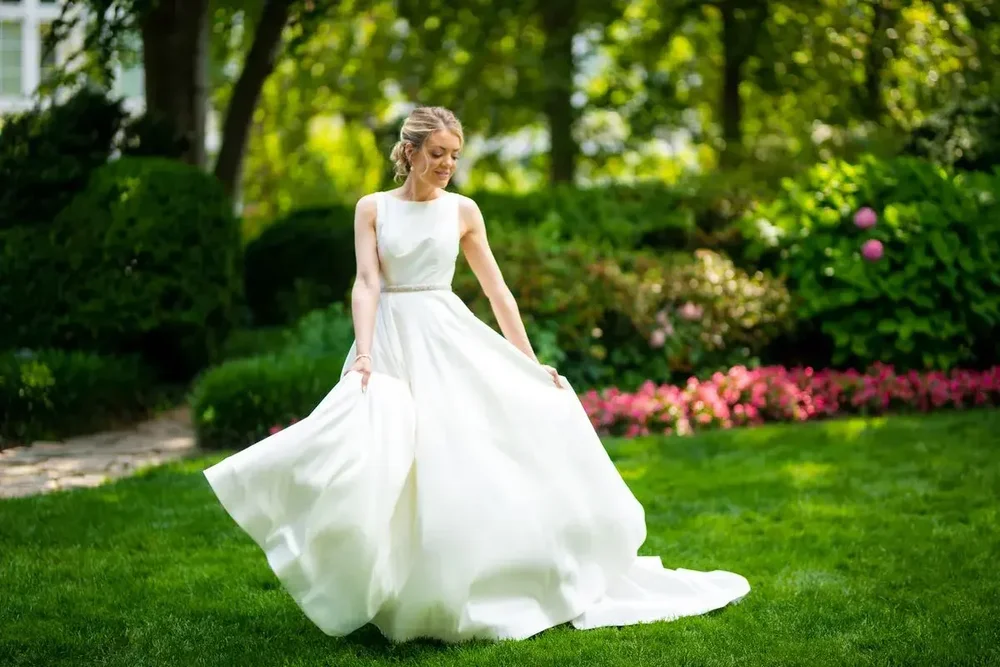 Bride twirling in her wedding dress in a garden at Meridian House