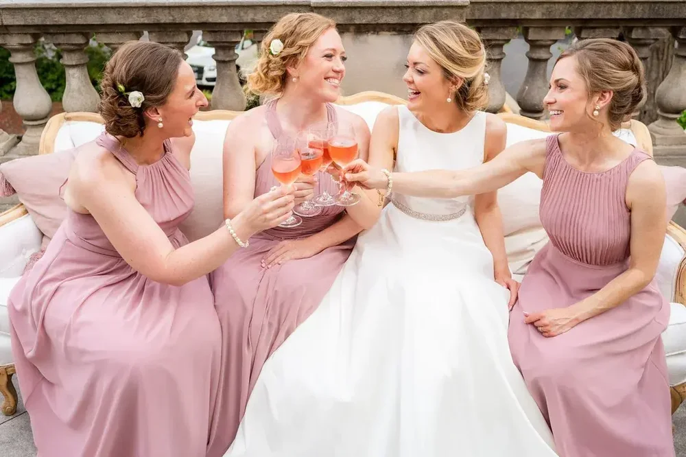 Bridesmaids in dusty rose toasting the bride with champagne at a Meridian House wedding reception